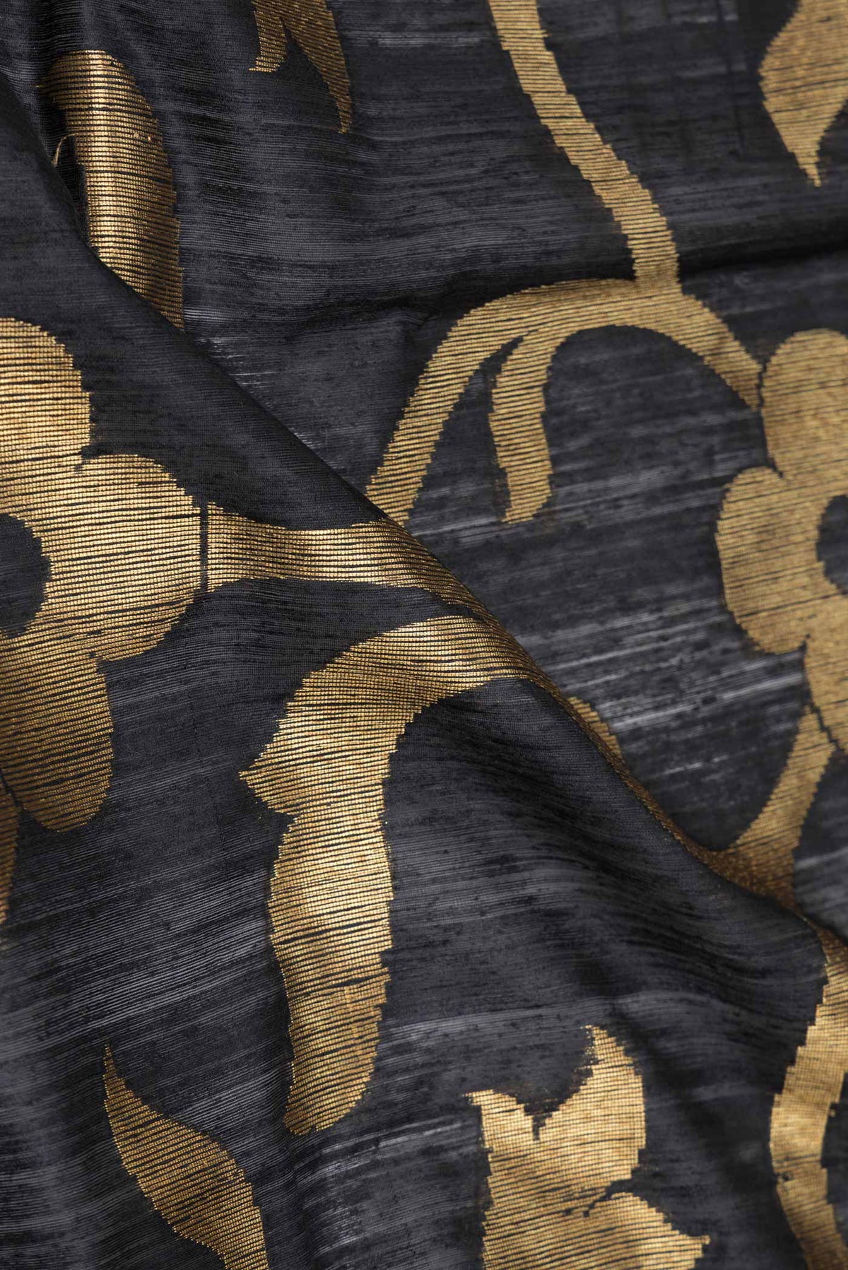 Close up of Black Dual Tone Raw Silk Saree with Zari Brocade on the body and Zari Border displaying folds