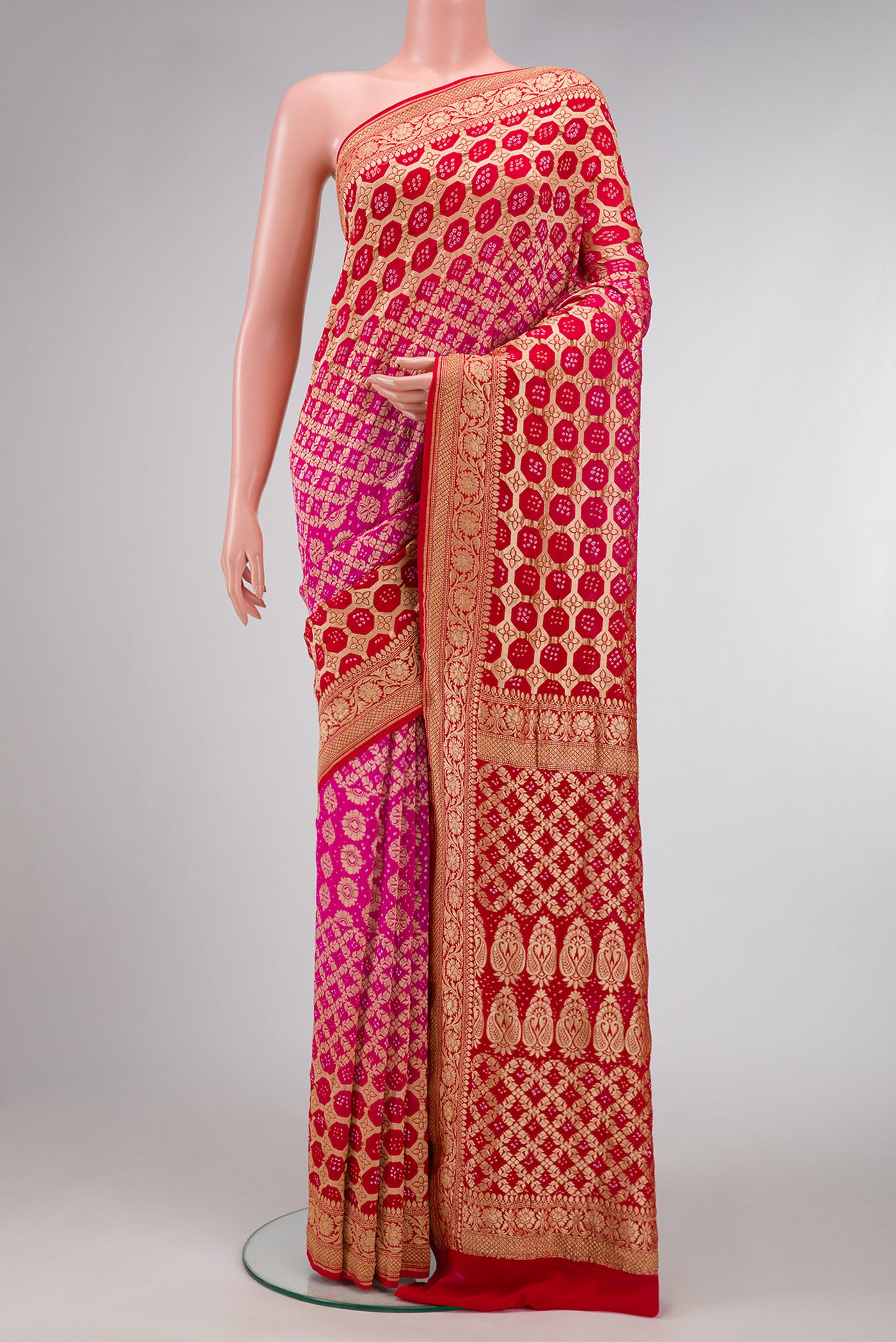 Pink and Red Color Bandhani Silk Saree with Bandhani Print on the body and Zari Border.  displayed on a mannequin