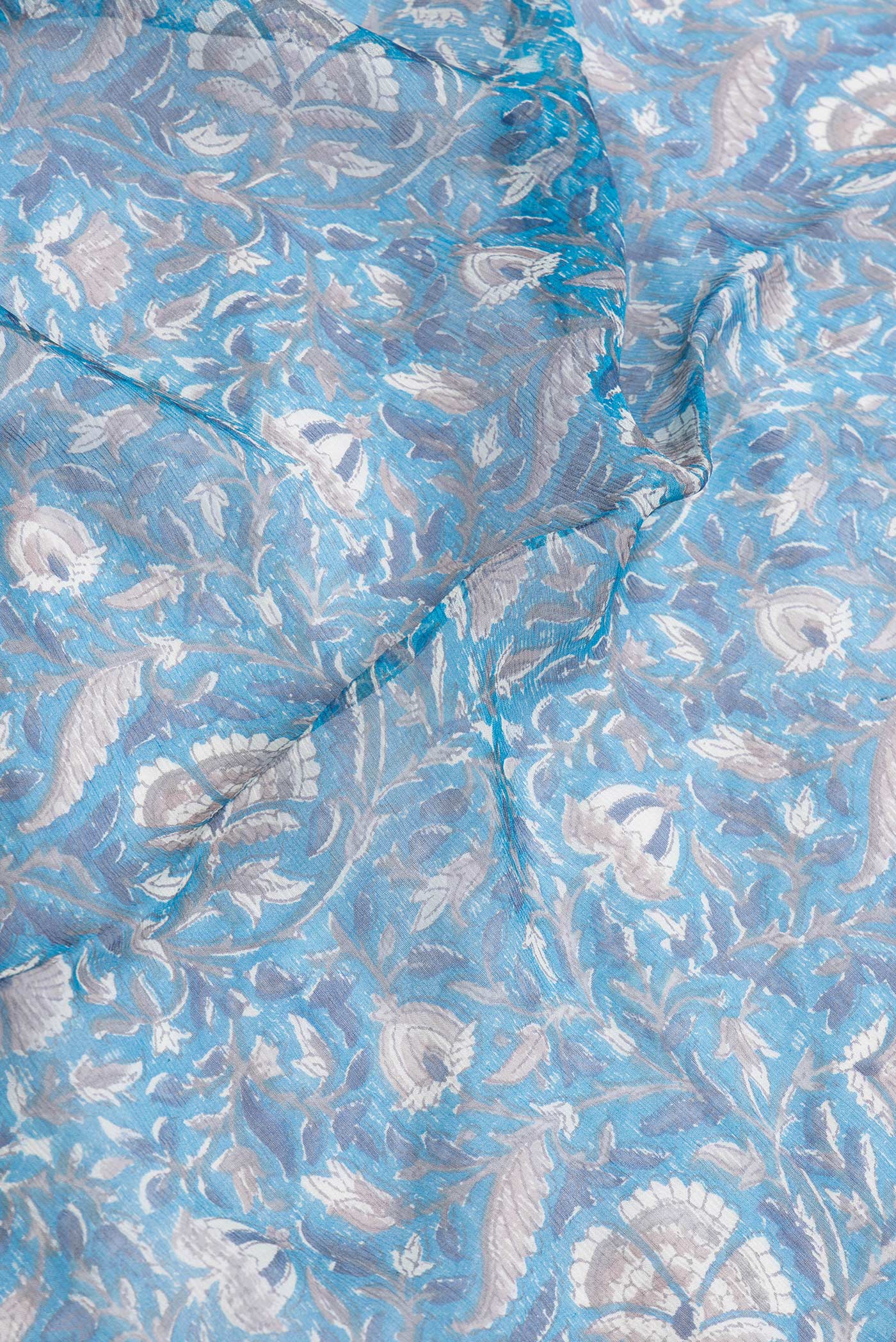 Close up of Peacock Blue Dual Tone Mysore Chiffon Saree with Printed design on the body and Zari Border.  displaying folds
