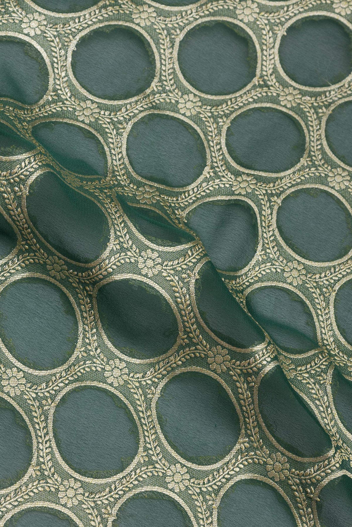 Close up of Bottle Green Banarasi Georgette Saree with Zari Brocade on the body and Zari Border.  displaying folds
