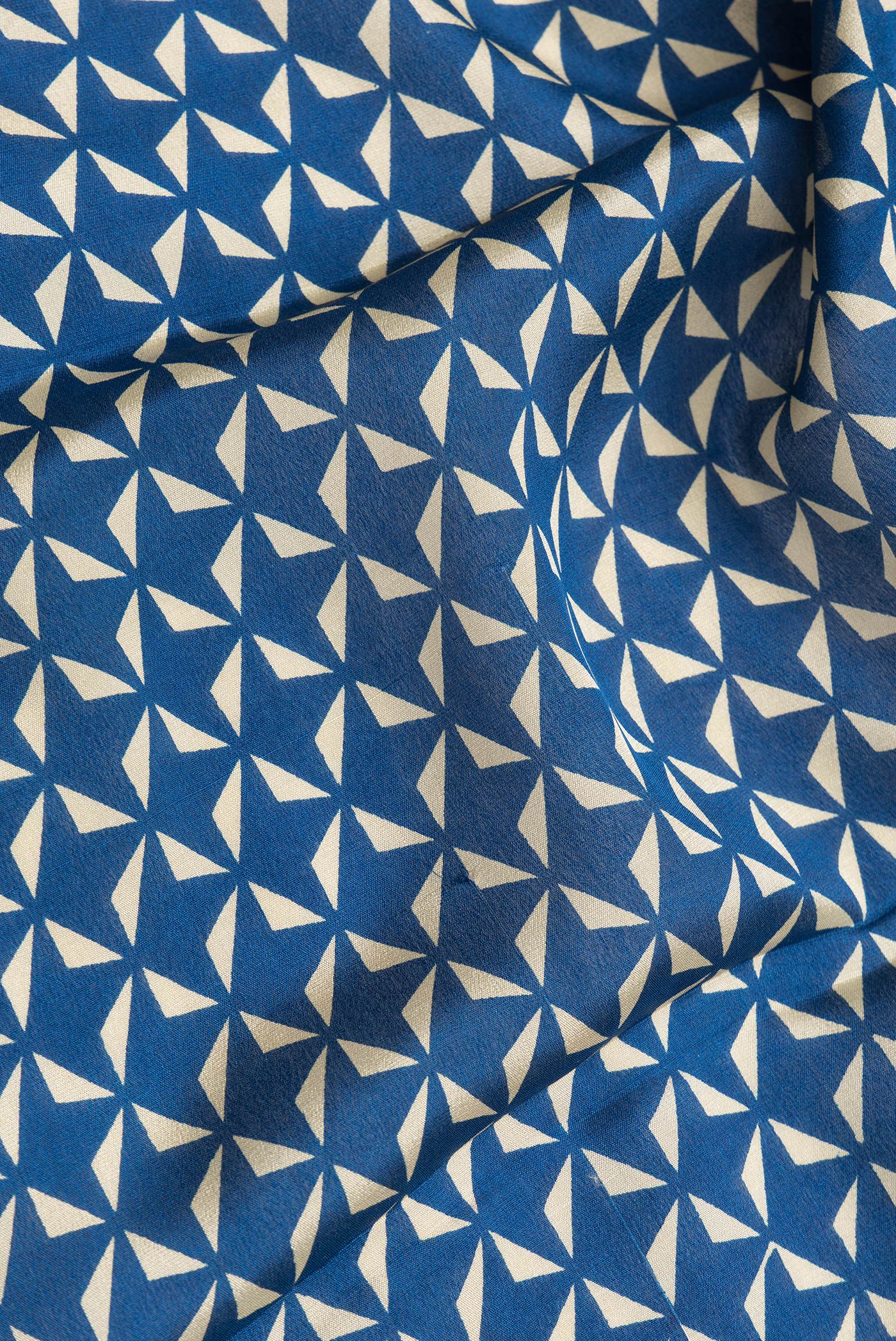 Close up of Navy Blue Dual Tone Crepe Saree with Printed design on the body and Zari Border.  displaying folds