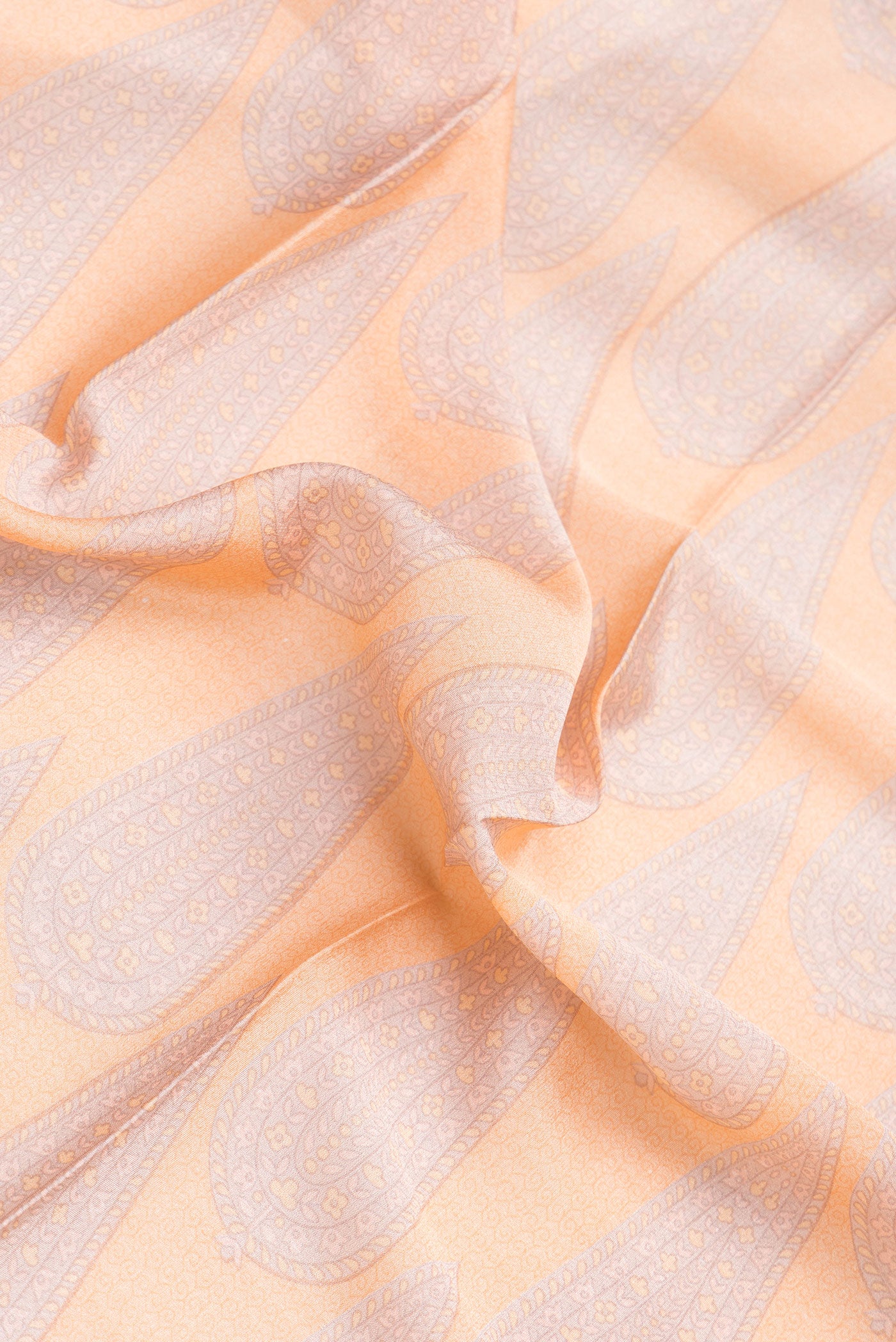 Close up of Peach Dual Tone Mysore Crepe Saree with Printed design on the body and Zari Border.  displaying folds