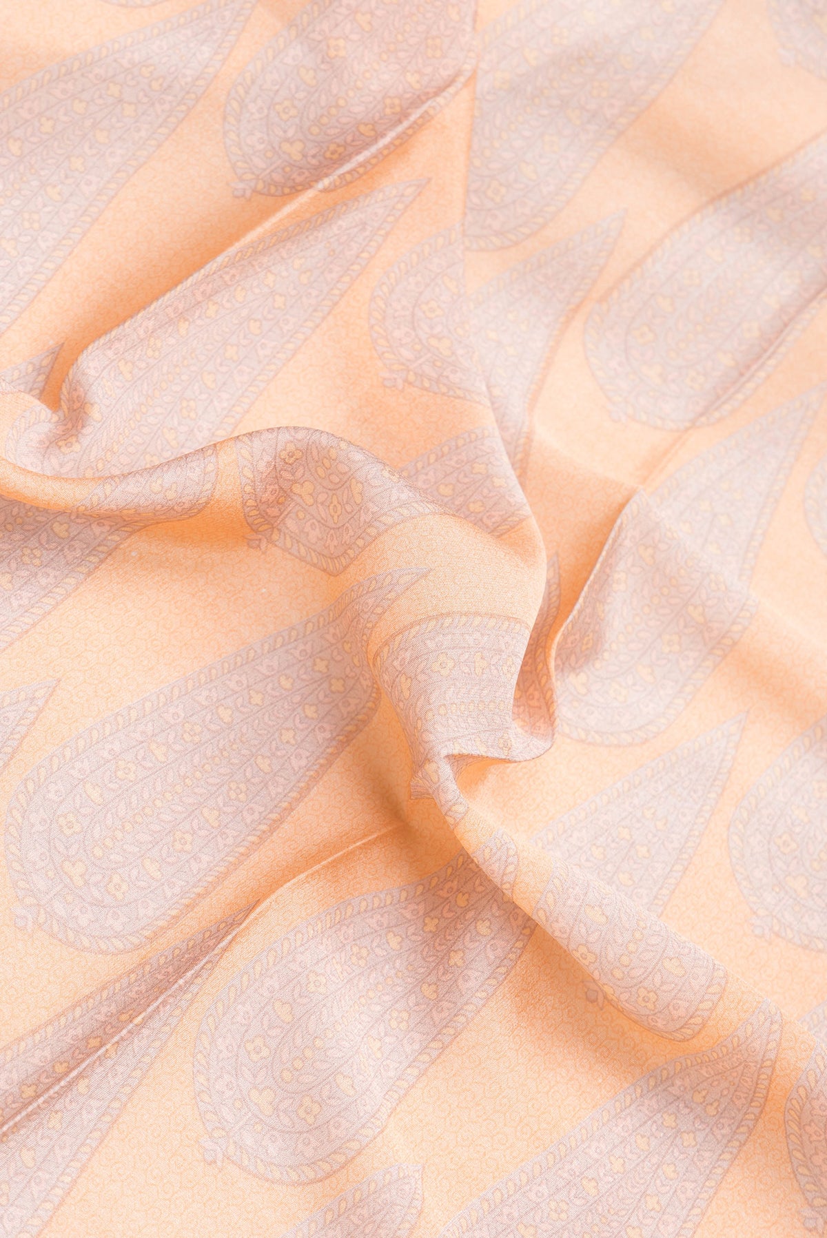 Close up of Peach Dual Tone Mysore Crepe Saree with Printed design on the body and Zari Border.  displaying folds