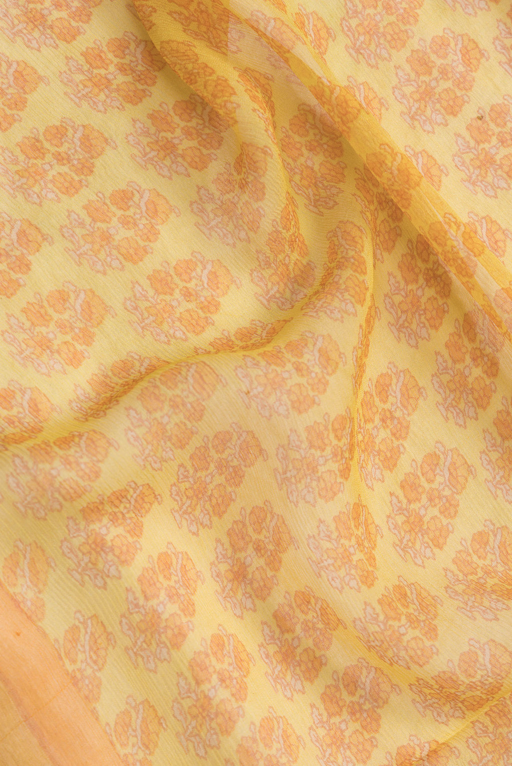 Close up of Mustard Dual Tone Mysore Chiffon Saree with Printed design on the body and Zari Border.  displaying folds