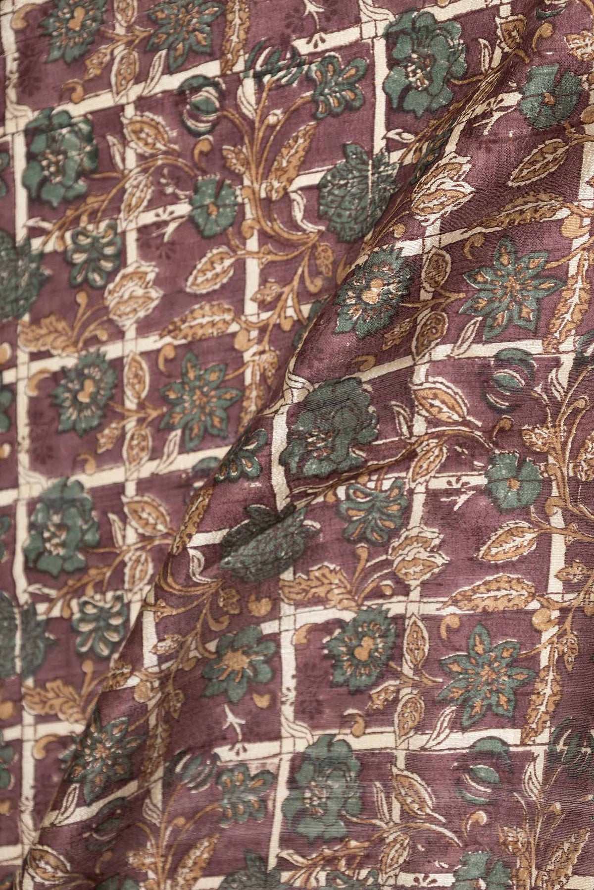 Close up of Brown Dual Tone Tussar Saree with Printed design on the body and Zari Border displaying folds