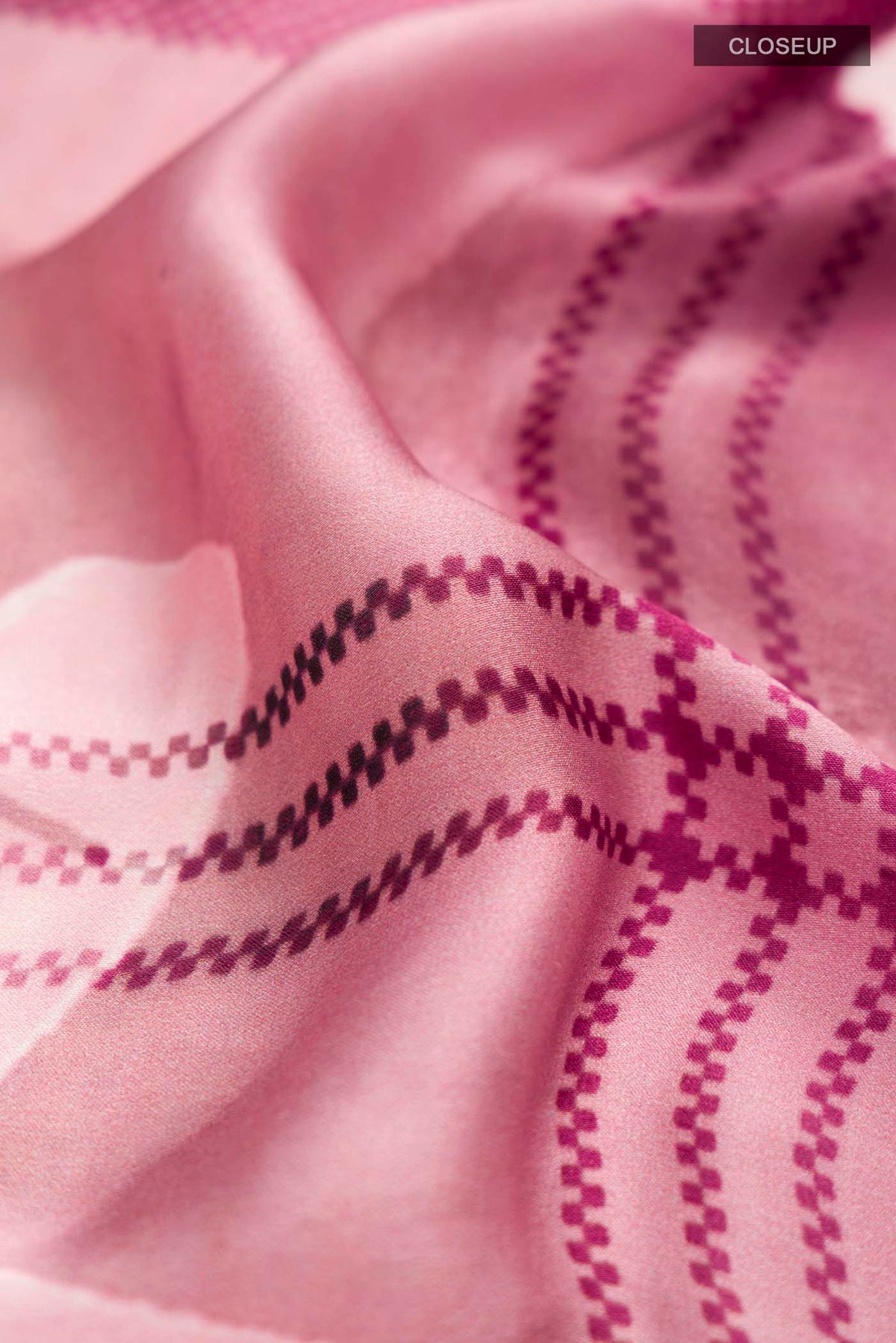 Close up of Rose pink Satin Silk Saree with Abstract Print on the body and Plain Border displaying folds