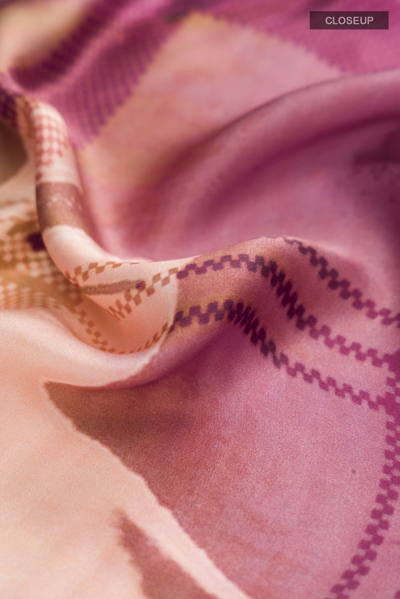Close up of Pink Satin Silk Saree with Abstract Print on the body and Plain Border displaying folds