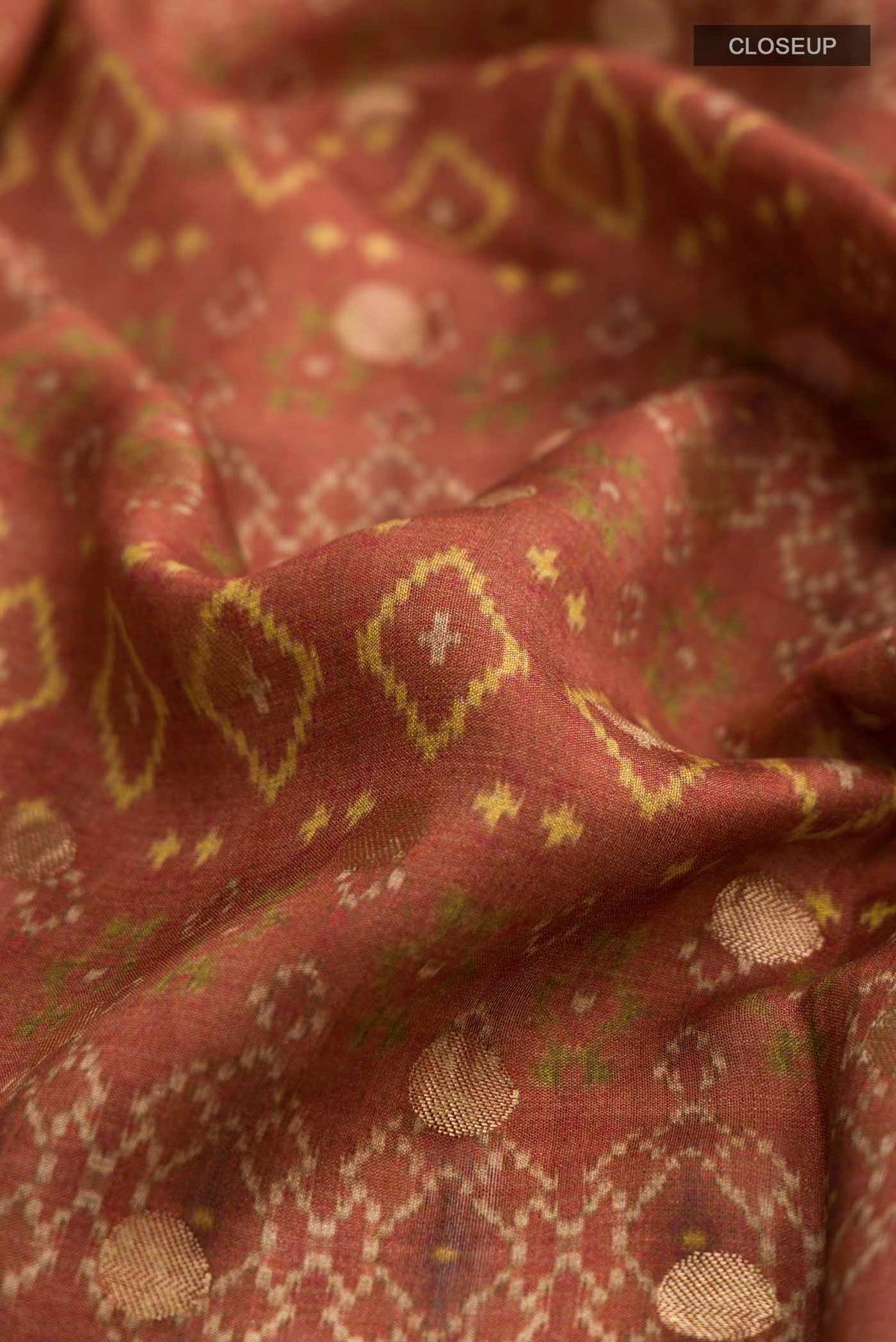 Close up of Rust Tussar Silk Saree with Printed design on the body and Zari Border displaying folds