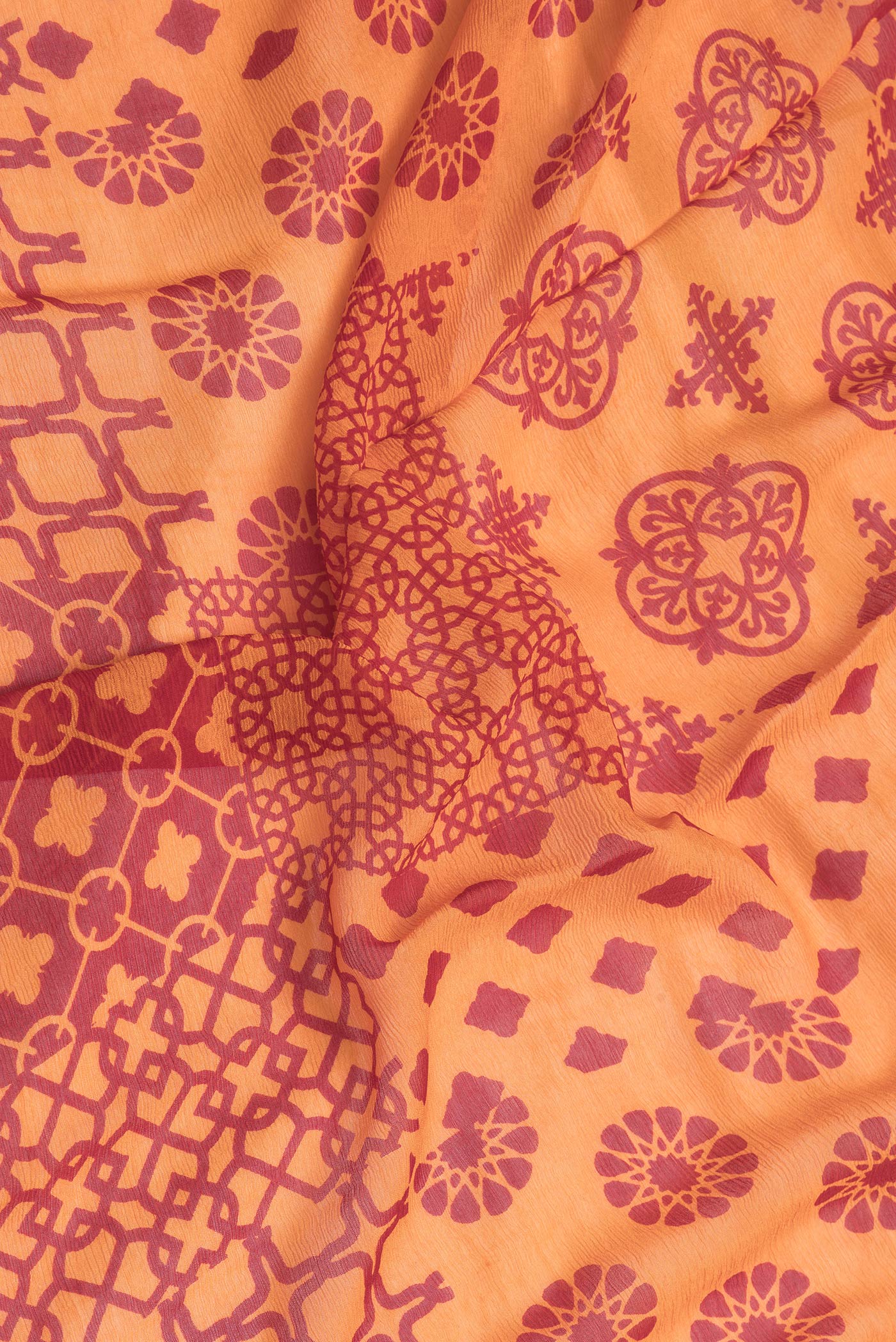 Close up of Orange Dual Tone Chiffon Saree with Printed design on the body and Checks Border.  displaying folds