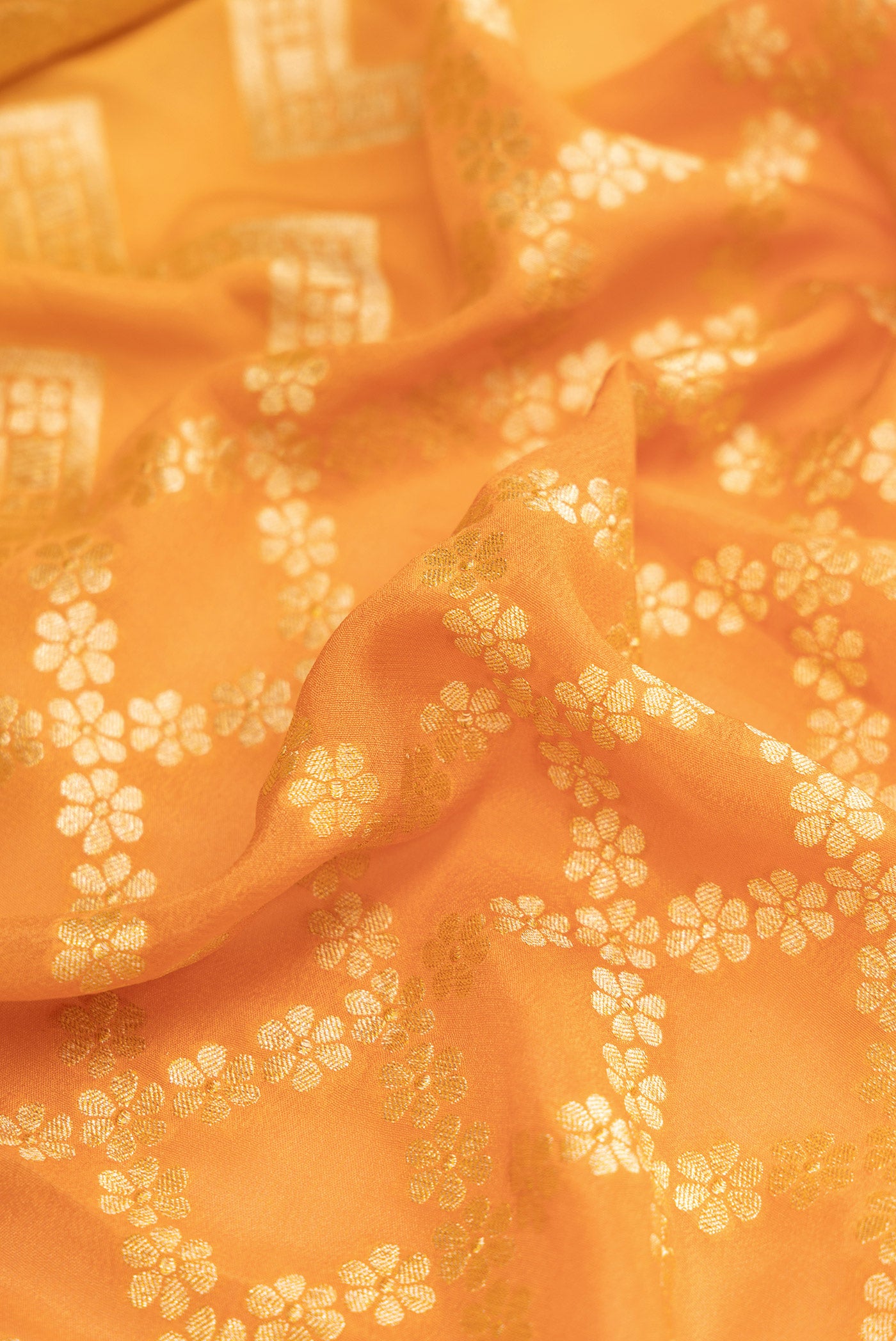 Close up of Orange Dual Tone Mysore Georgette Saree with Zari Brocade on the body and Zari Border.  displaying folds