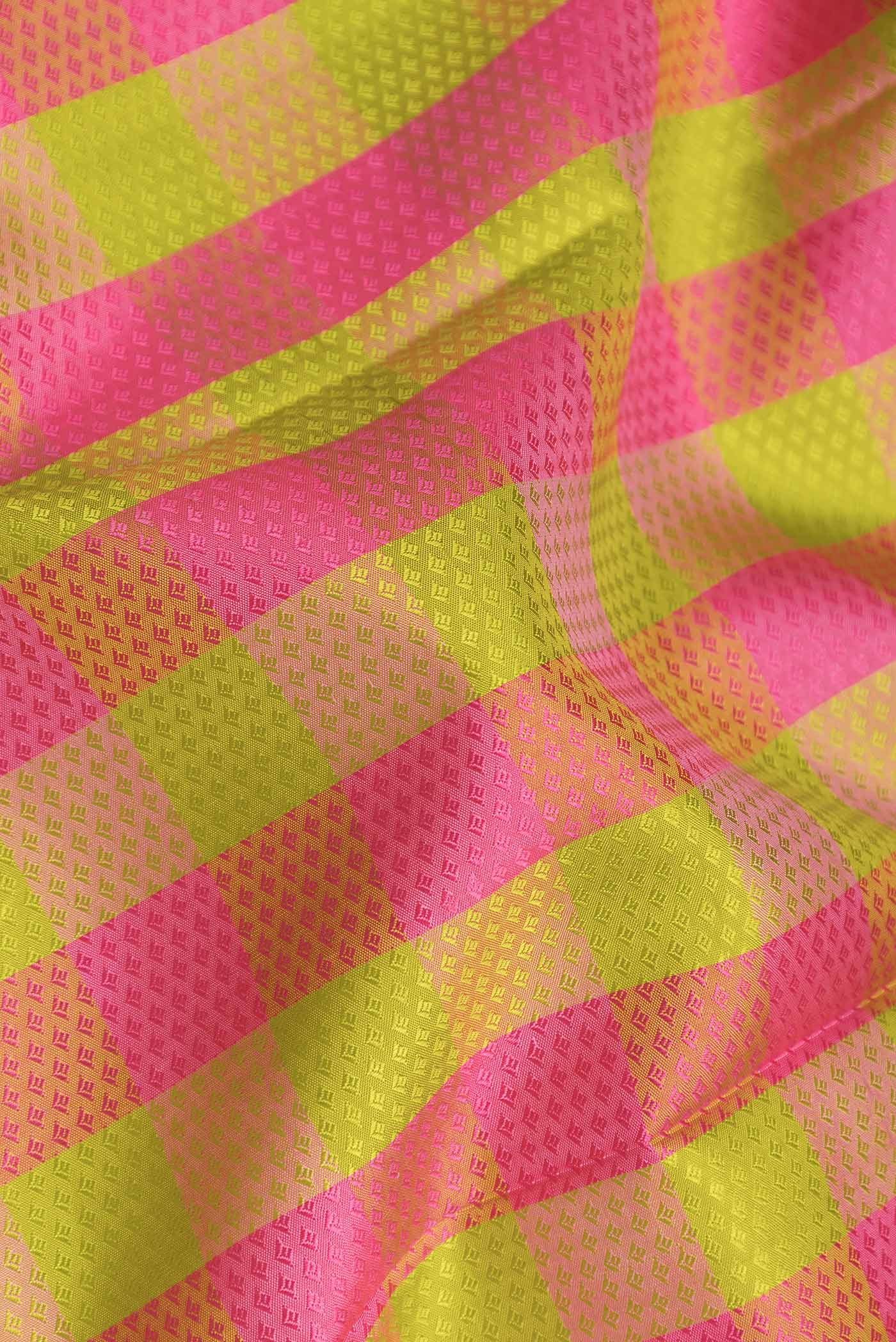 Close up of Parrot Green and Pink Color Kanchipuram Saree with Jacquard design on the body and Zari Border displaying folds