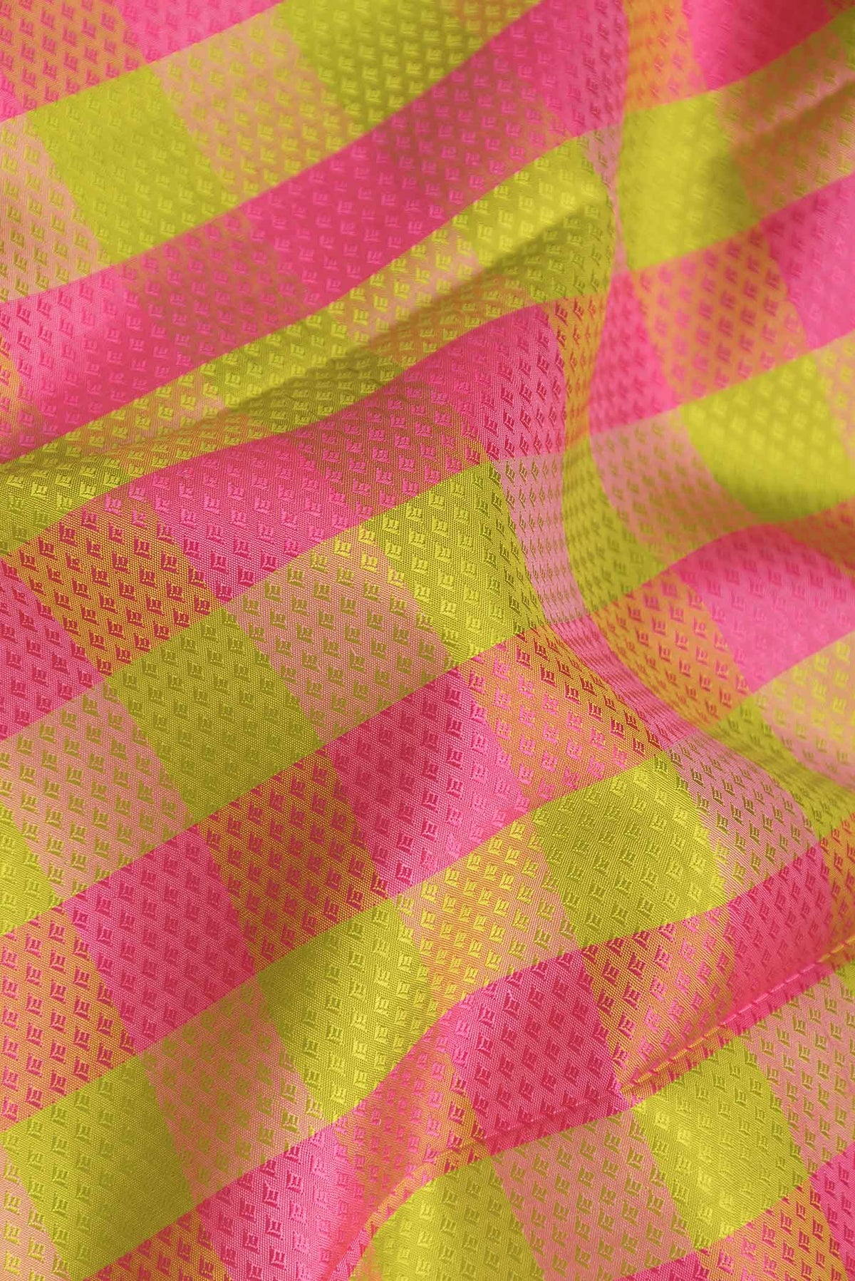 Close up of Parrot Green and Pink Color Kanchipuram Saree with Jacquard design on the body and Zari Border displaying folds