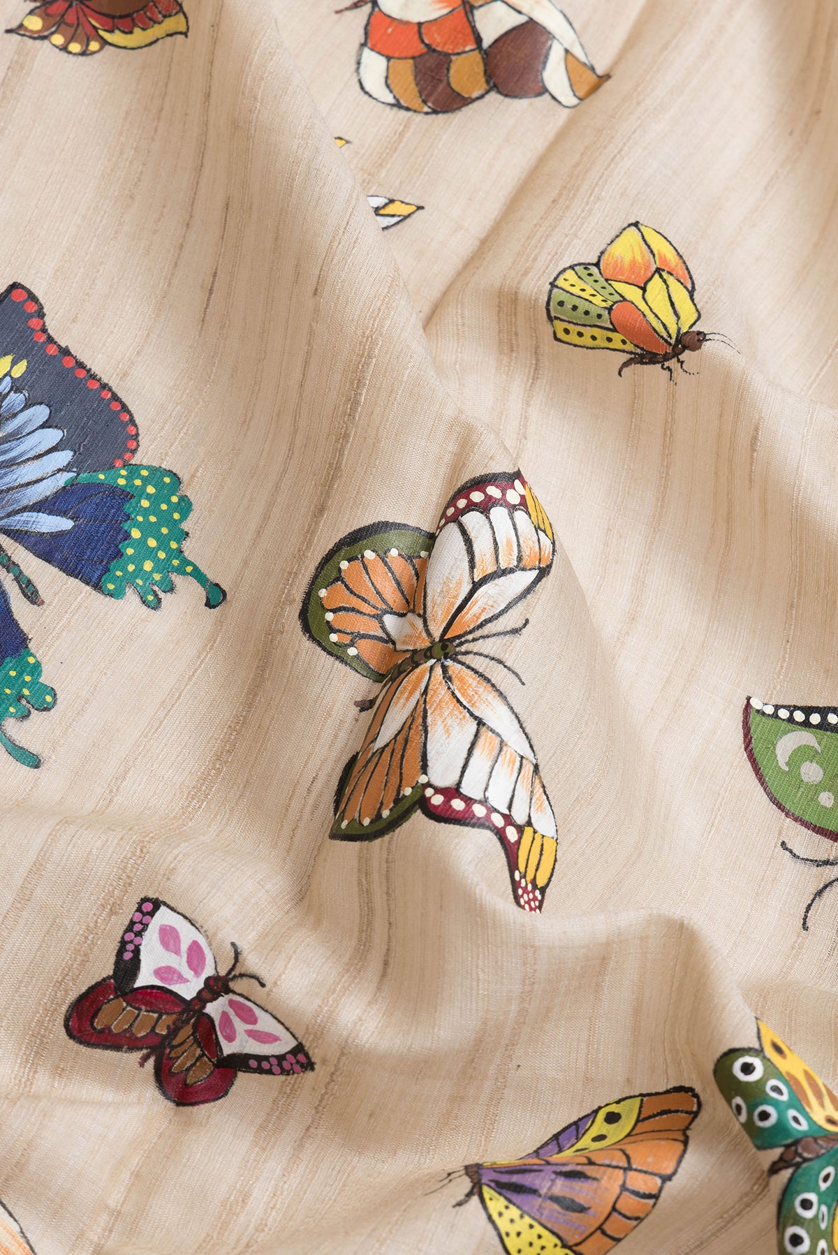 Close up of Beige Dual Tone Tussar Silk Saree with Printed design on the body and Zari Border.  displaying folds