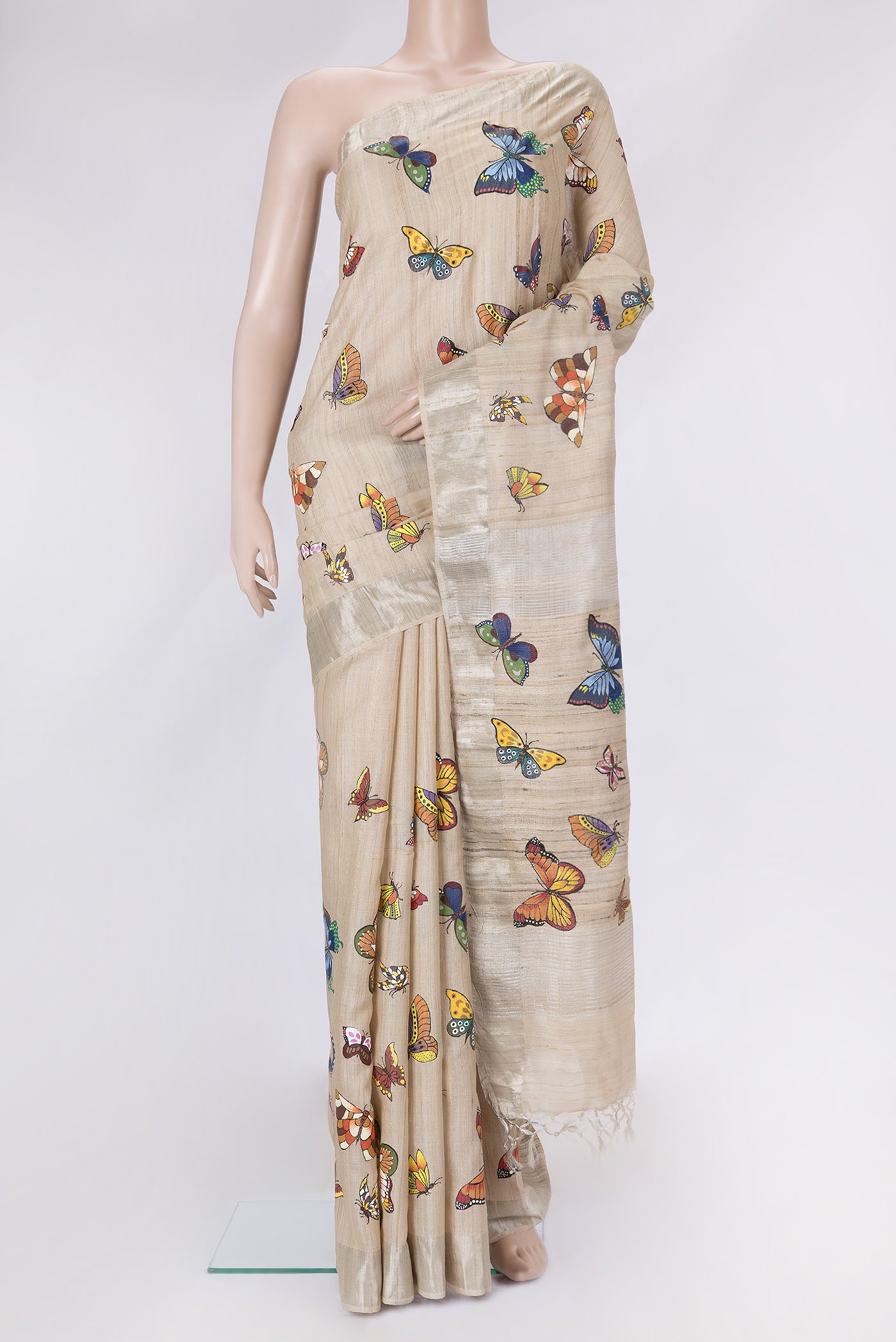 Beige Dual Tone Tussar Silk Saree with Printed design on the body and Zari Border.  displayed on a mannequin
