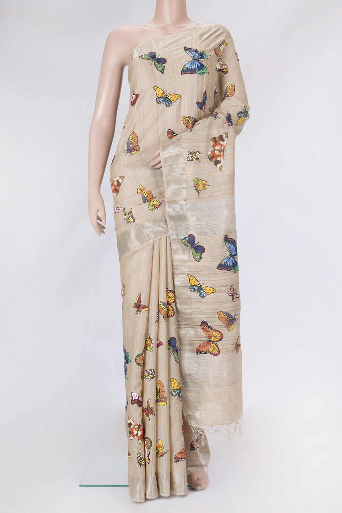 Beige Dual Tone Tussar Silk Saree with Printed design on the body and Zari Border.  displayed on a mannequin