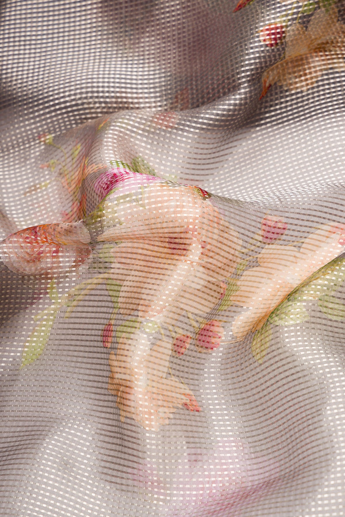 Close up of Grey Dual Tone Organza Silk Saree with Printed design on the body and Without Border.  displaying folds