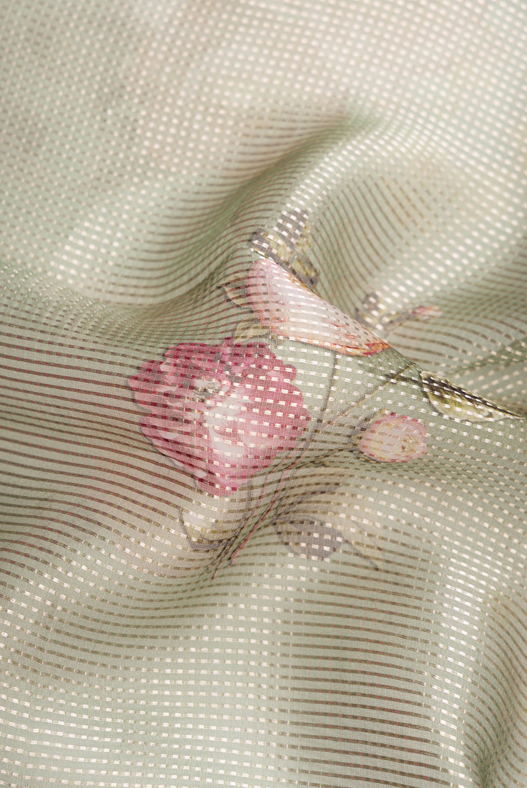 Close up of Green Dual Tone Organza Silk Saree with Printed design on the body and Without Border.  displaying folds