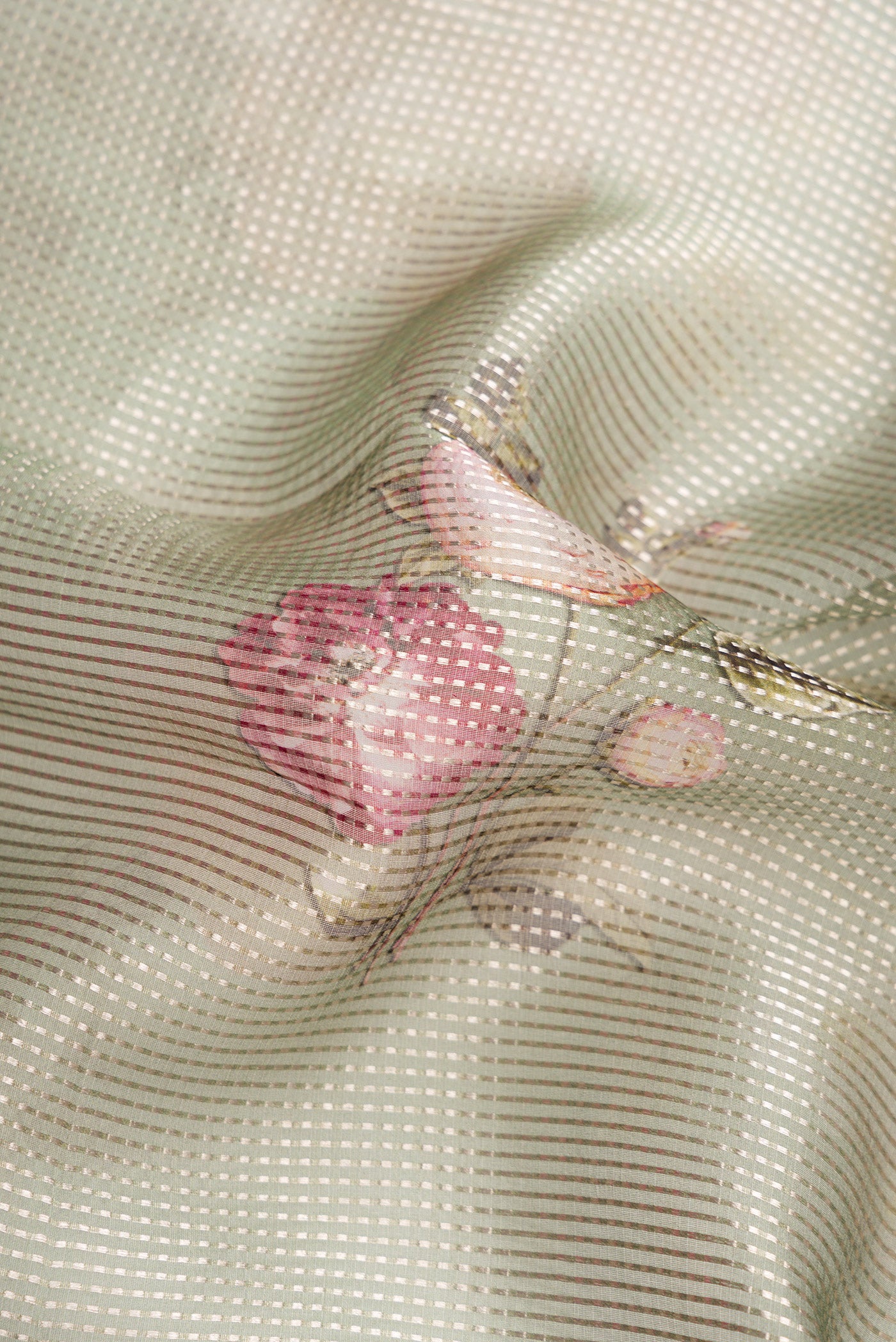Close up of Green Dual Tone Organza Silk Saree with Printed design on the body and Without Border.  displaying folds