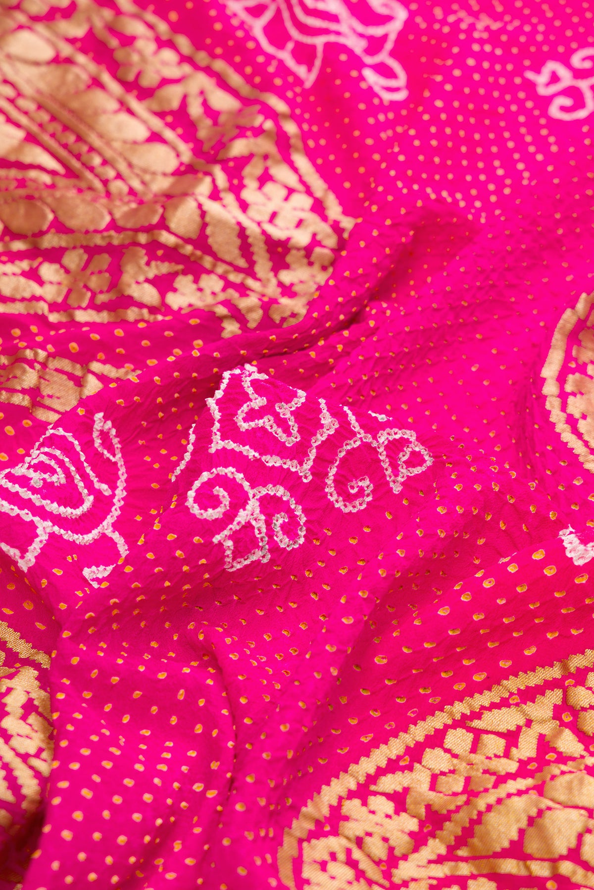 Close up of Pink Dual Tone Bandhani Silk Saree with Bandhani Print on the body and Fancy Border.  displaying folds