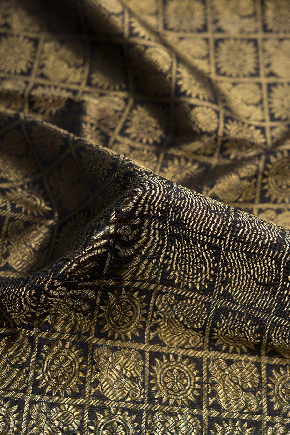 Close up of Pure Silk Pure Zari Black Dual Tone Kanjivaram Saree with Zari Brocade on the body and Zari Border.  displaying folds