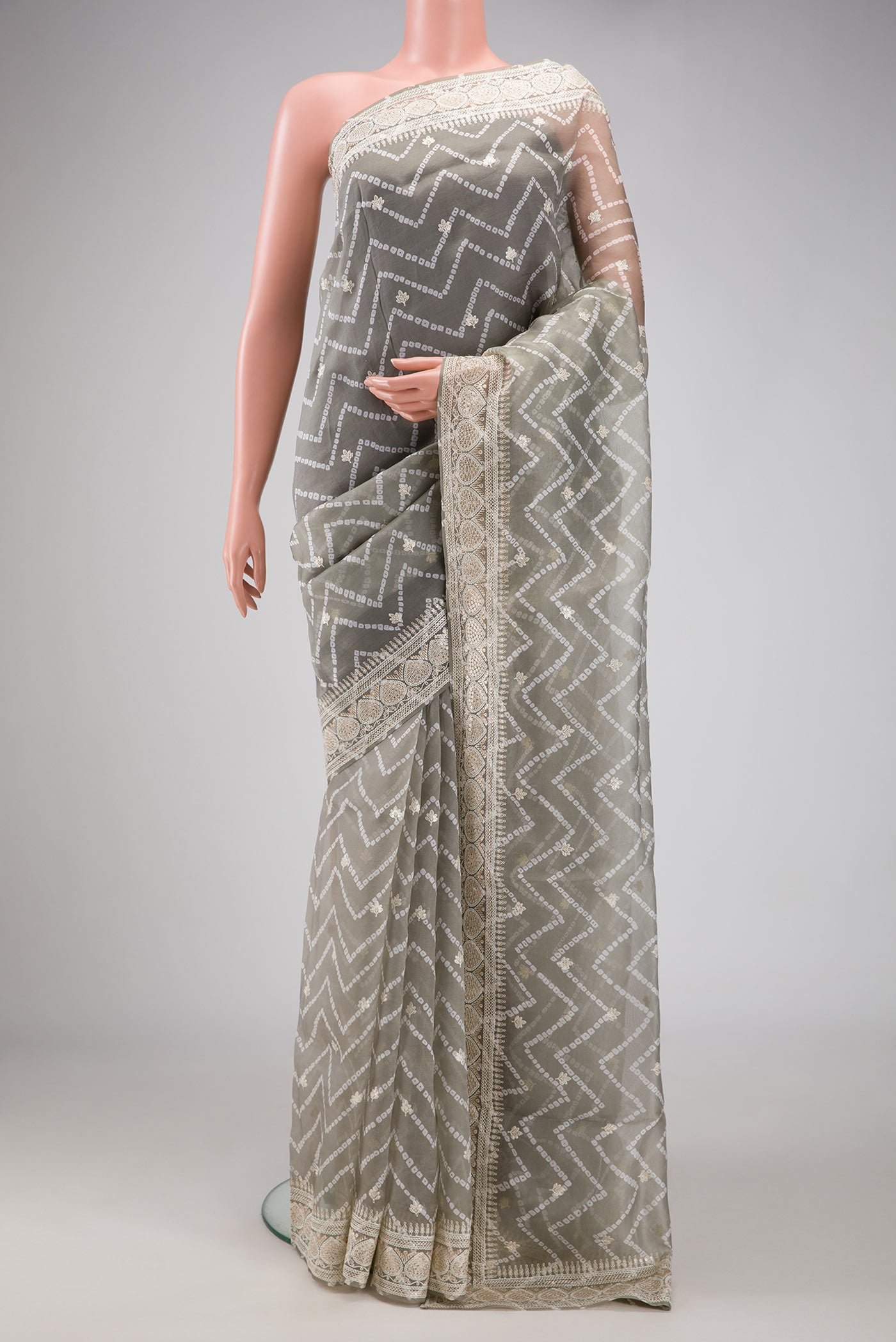 Grey Dual Tone Organza Silk Saree with Printed design on the body and Embroidery Border.  displayed on a mannequin