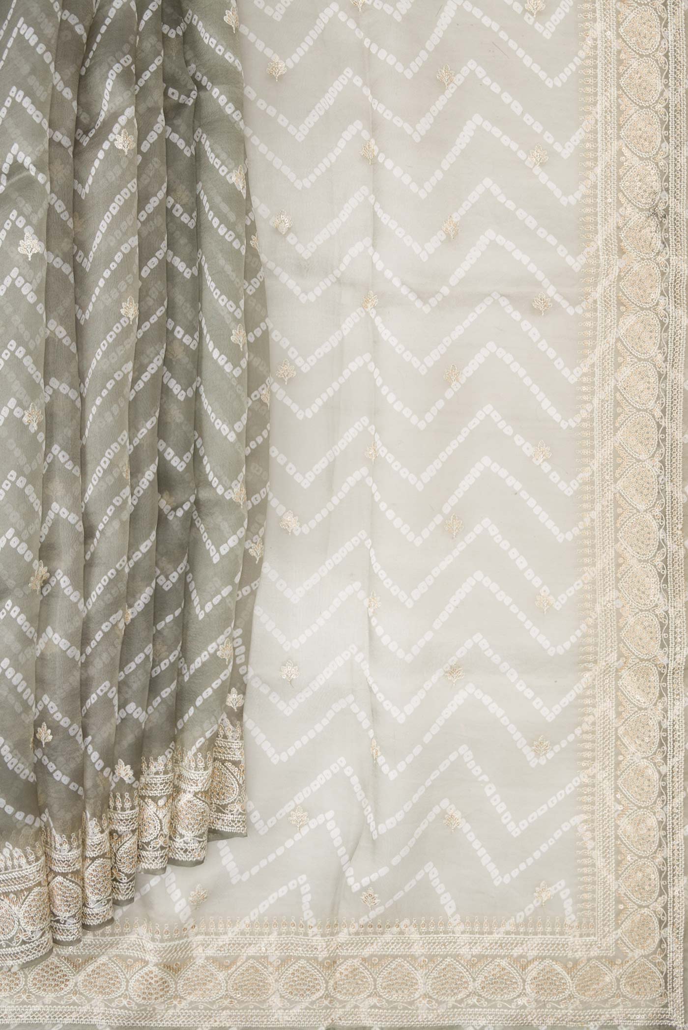 Pleats and pallu of Grey Dual Tone Organza Silk Saree with Printed design on the body and Embroidery Border. 