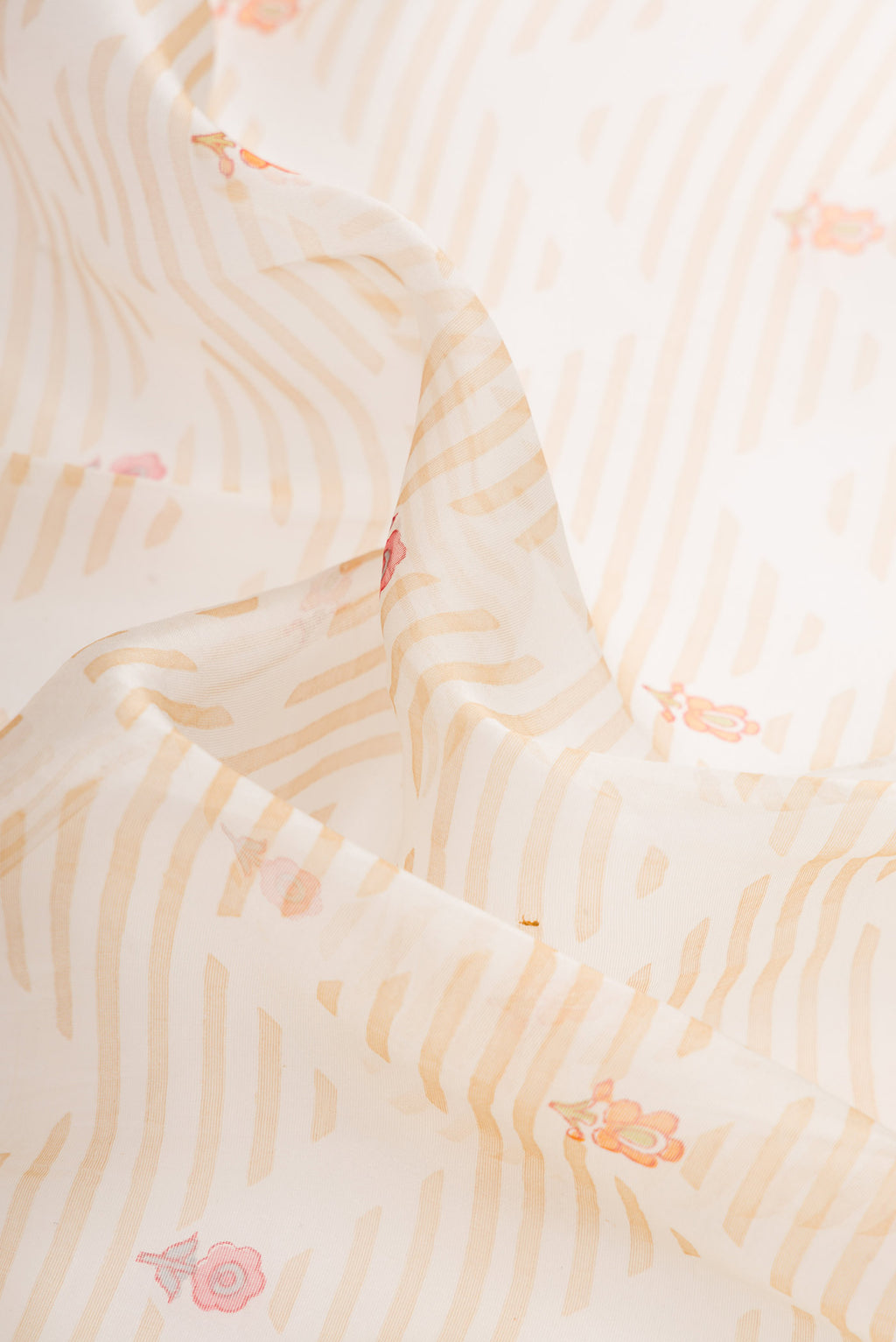 Close up of Off White Dual Tone Organza Silk Saree with Printed design on the body and Embroidery Border.  displaying folds