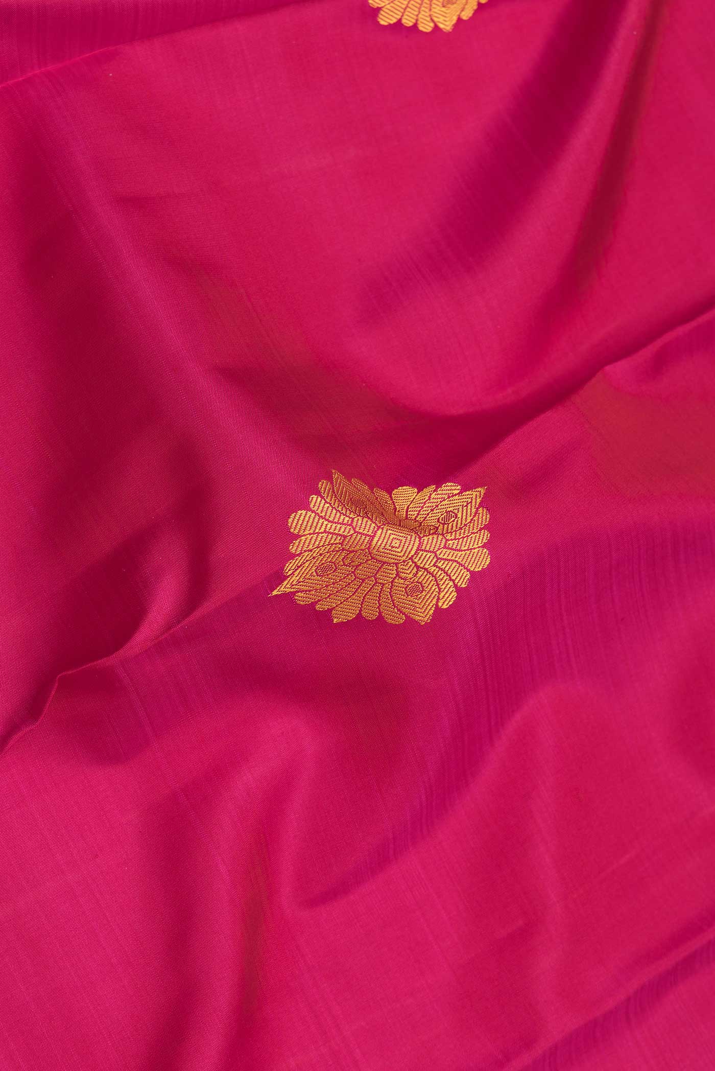 Close up of Pink Dual Tone Kanjivaram Saree with Thread Butta on the body and Thread Border.  displaying folds