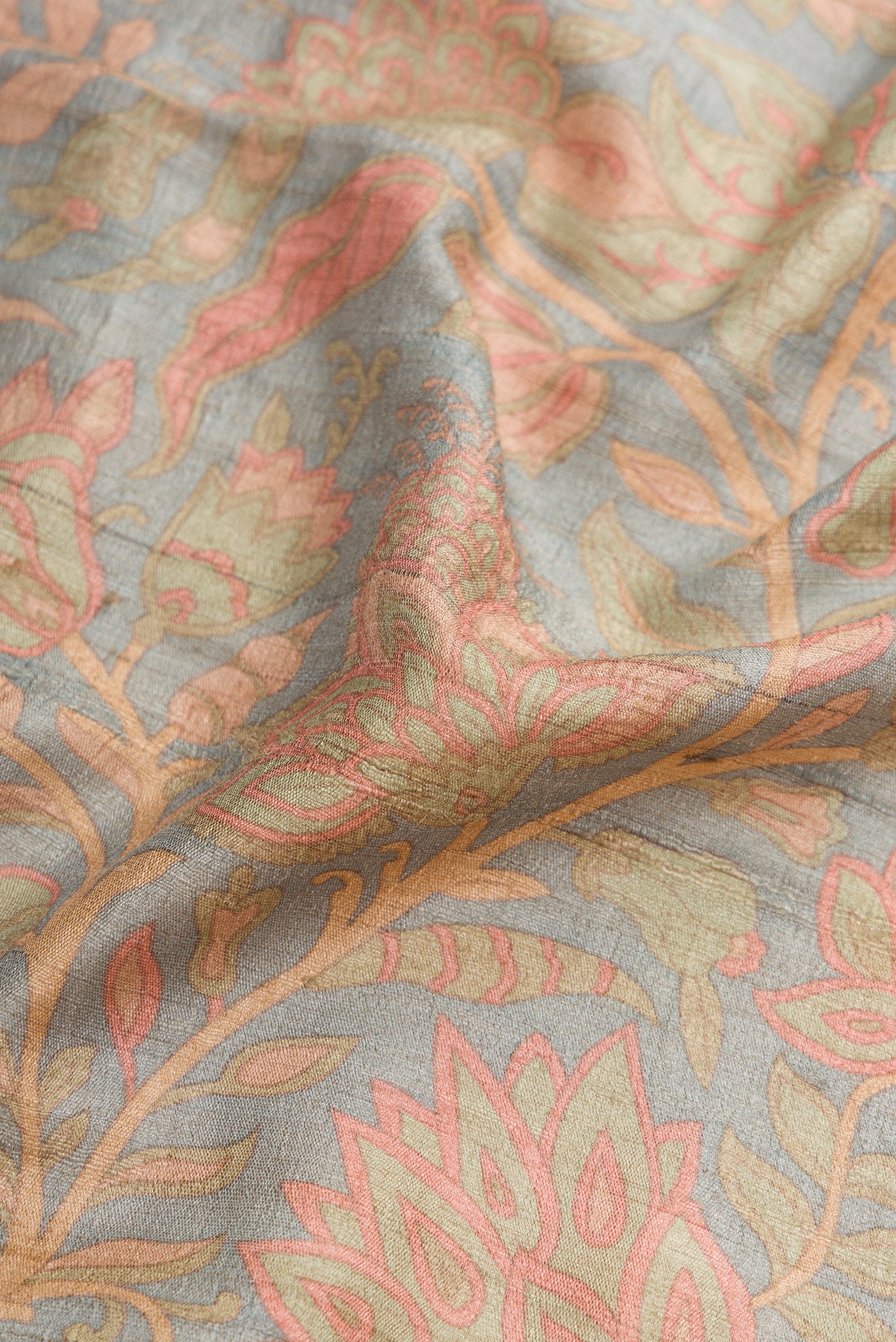 Close up of Beige Dual Tone Tussar Silk Saree with Printed design on the body and Thread Border.  displaying folds
