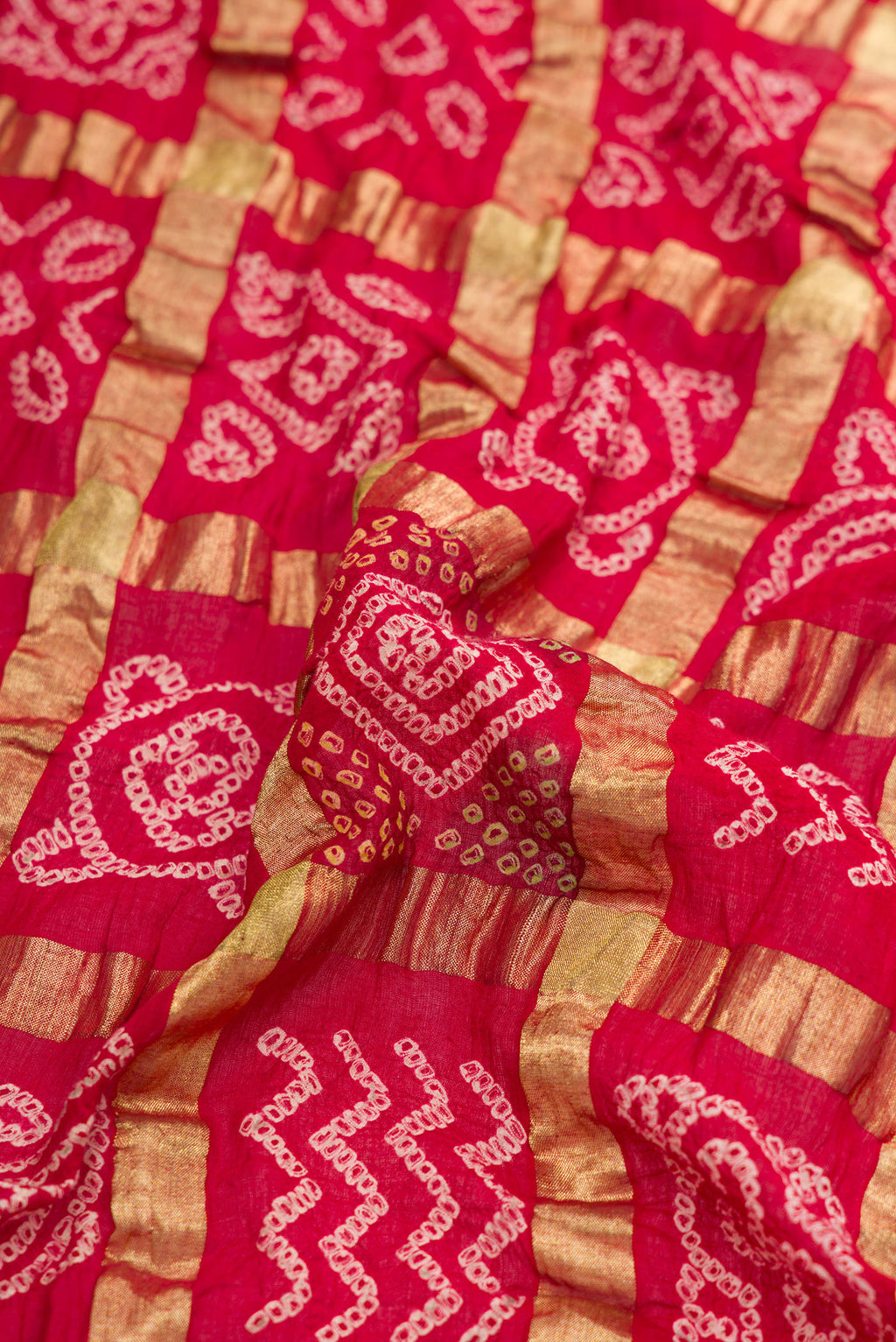 Close up of Red Dual Tone Bandhani Silk Saree with Bandhani Print on the body and Paithani Border.  displaying folds