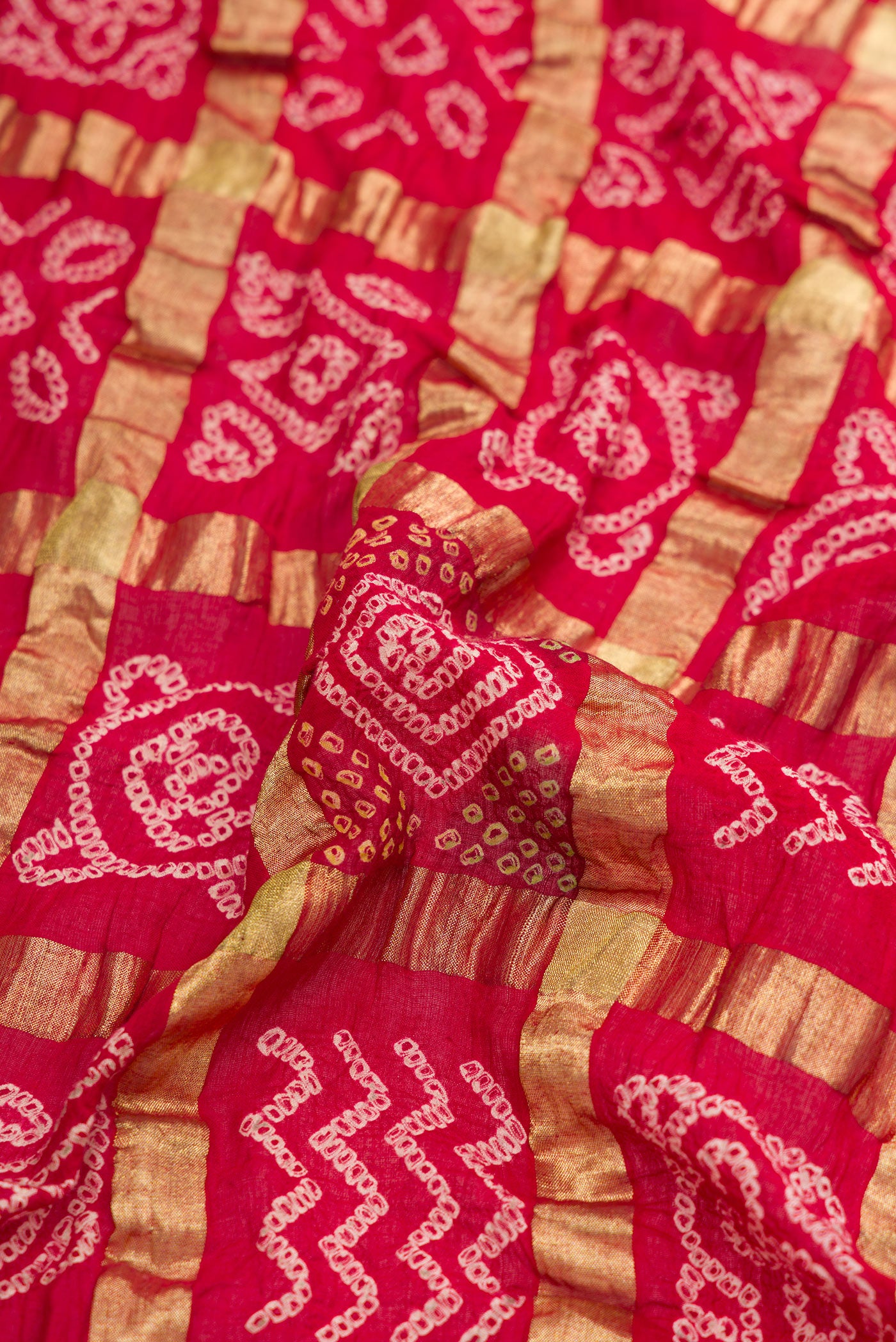 Close up of Red Dual Tone Bandhani Silk Saree with Bandhani Print on the body and Paithani Border.  displaying folds