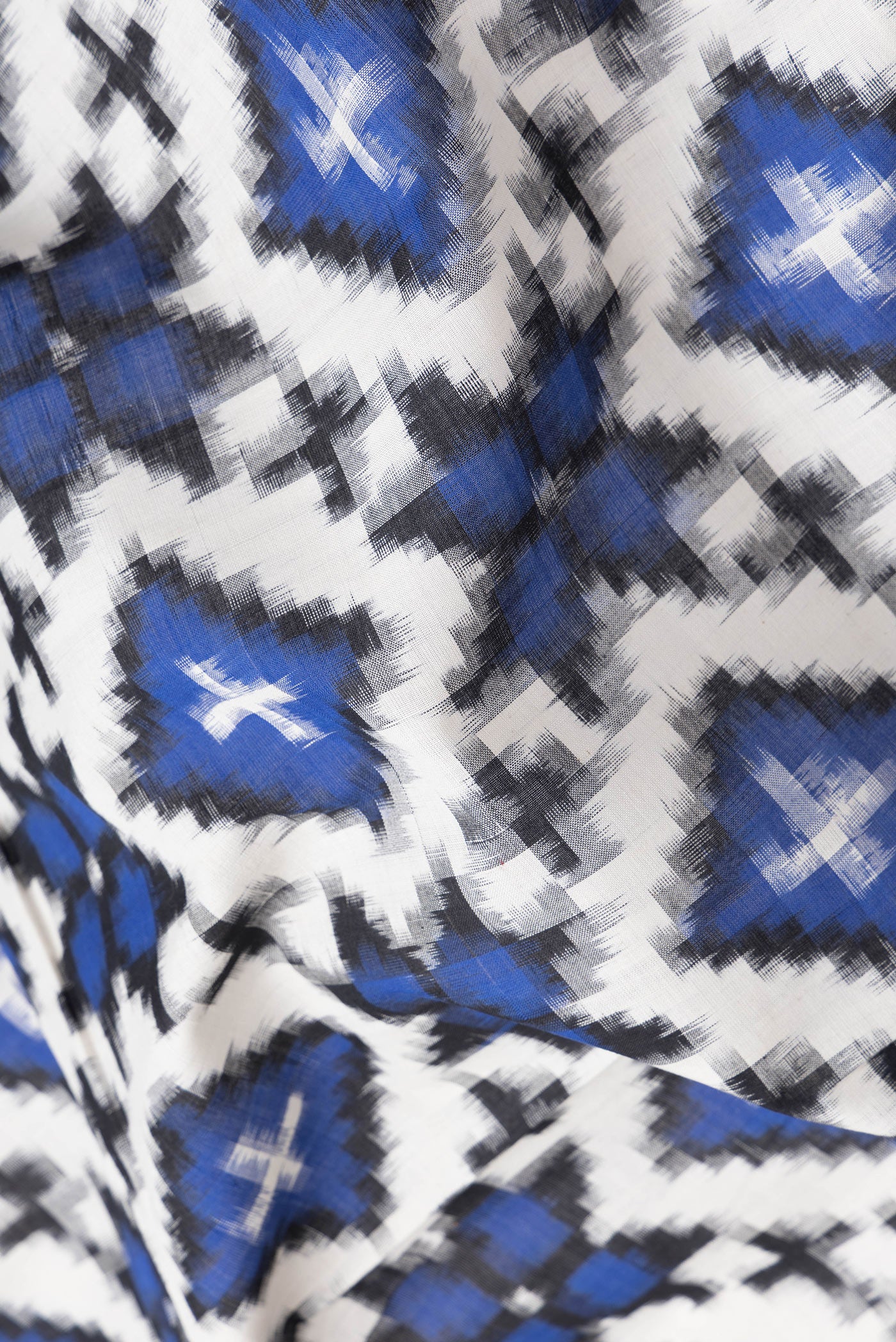 Close up of Off White Dual Tone Double Ikat Saree with Ikat Print on the body and Thread Border.  displaying folds