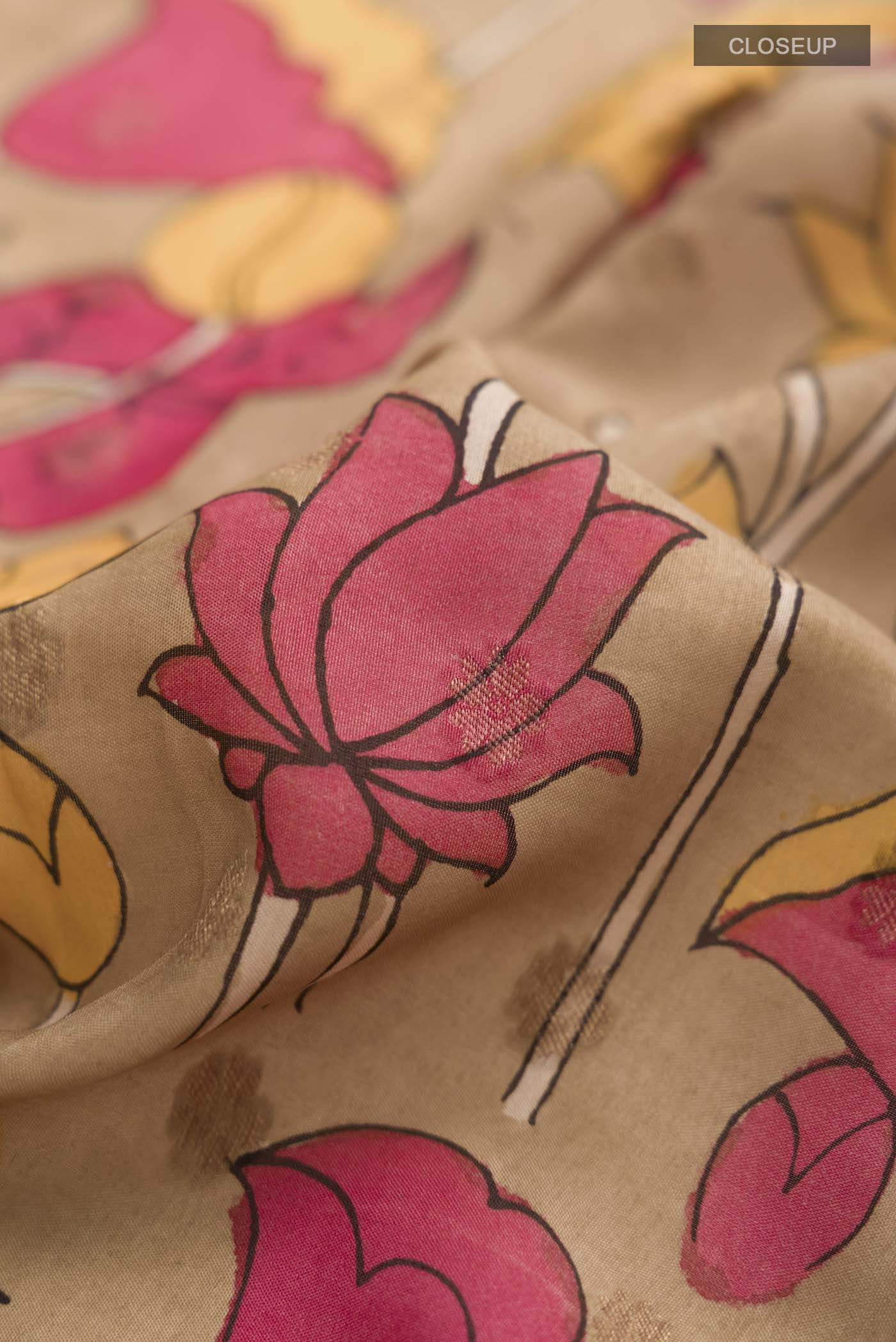 Close up of Beige Kalamkari Cotton Saree with kalamkari Print on the body and Zari Border displaying folds