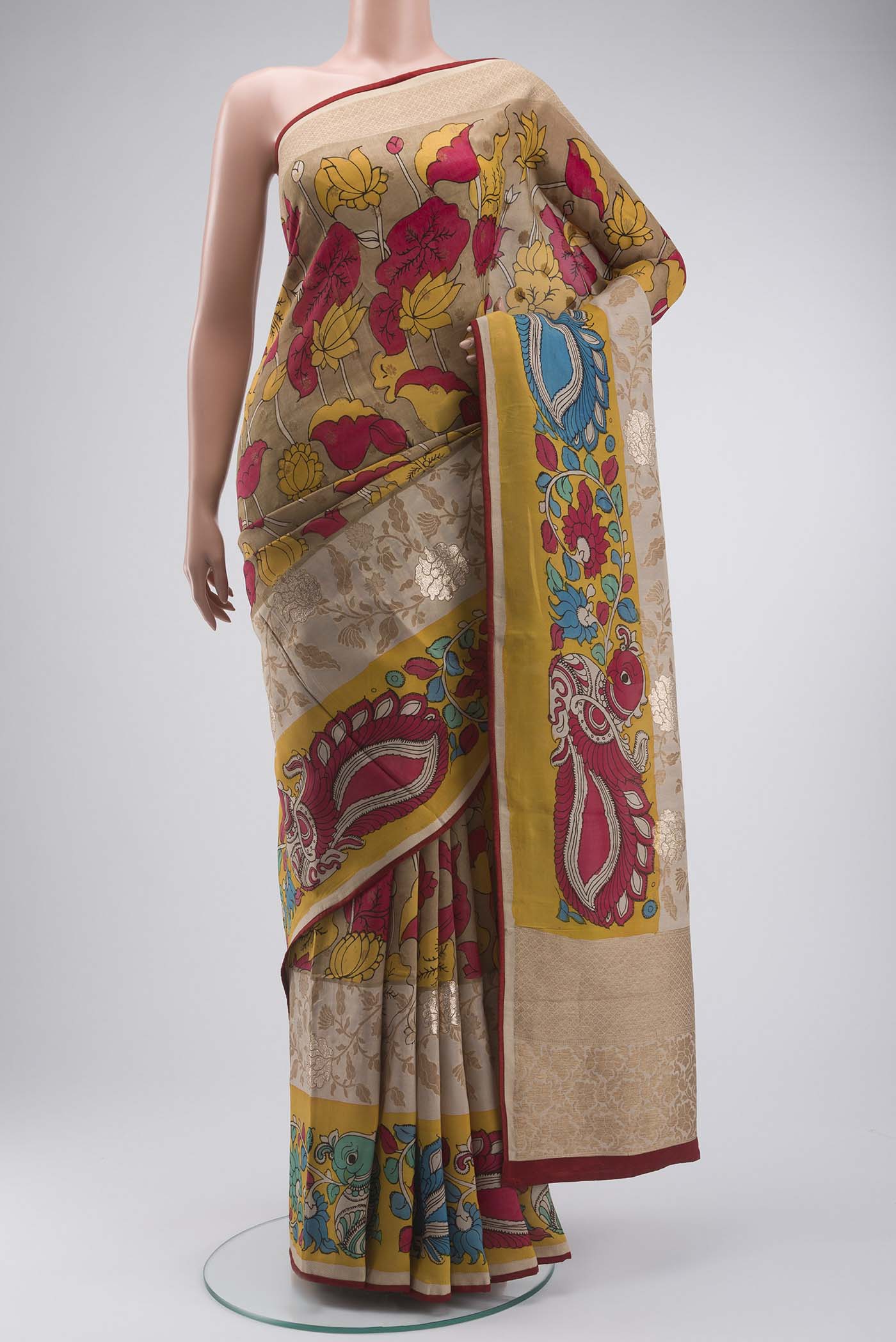 Beige Kalamkari Cotton Saree with kalamkari Print on the body and Zari Border displayed on a mannequin