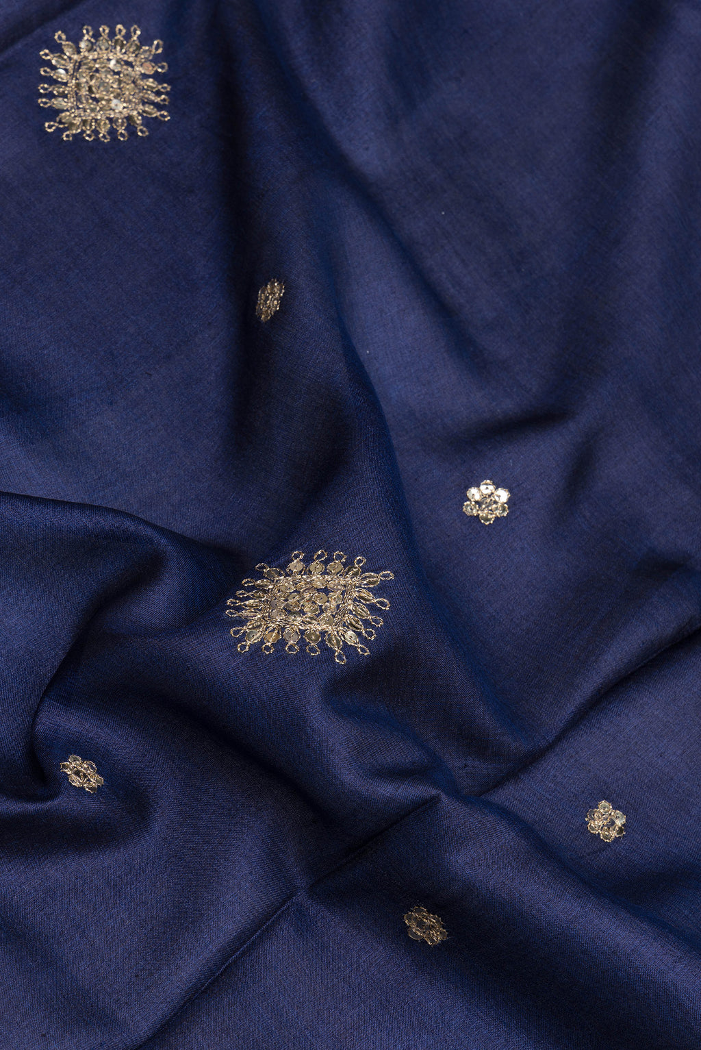 Close up of Navy Blue Tussar Silk Saree with Embroidery on the body and Zari Border.  displaying folds