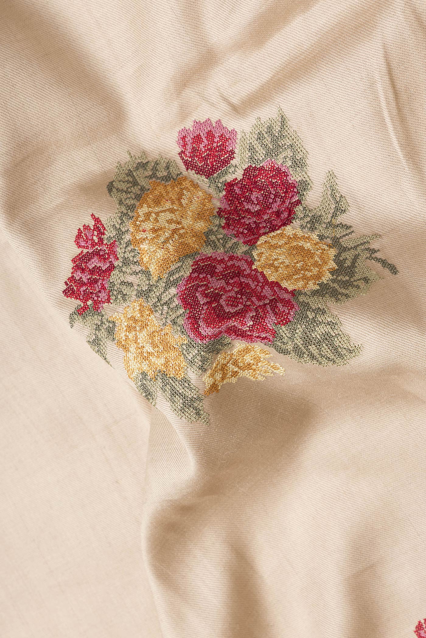 Close up of Beige Dual Tone Tussar Silk Saree with Embroidery on the body and Zari Border.  displaying folds