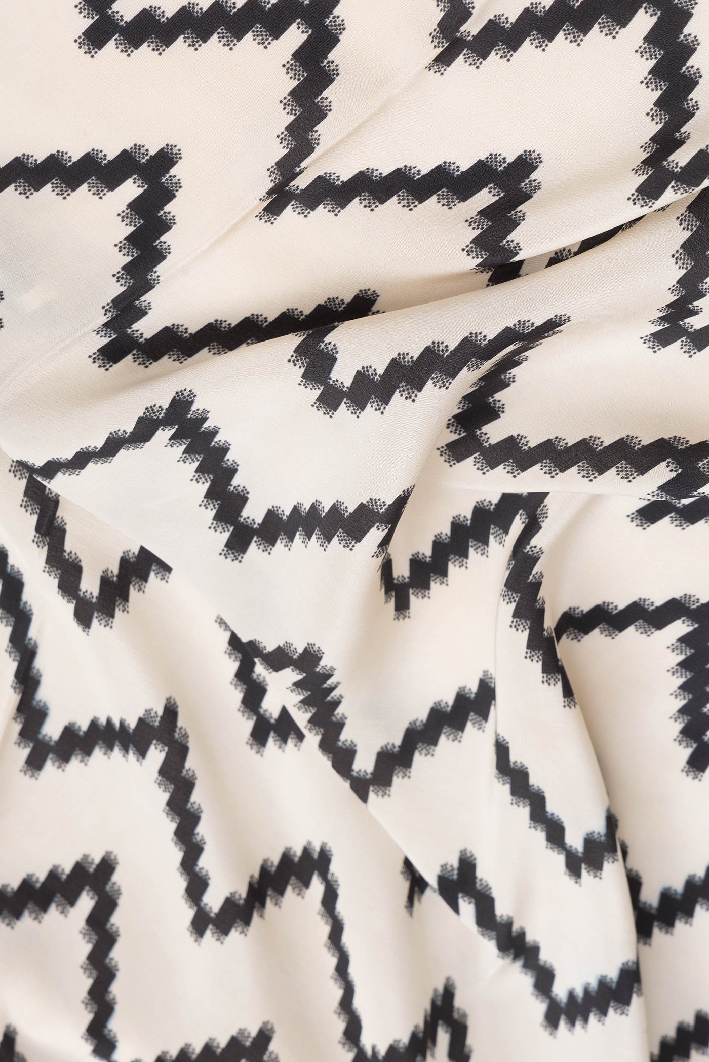 Close up of Beige Dual Tone Mysore Crepe Saree with Printed design on the body and Printed Border.  displaying folds