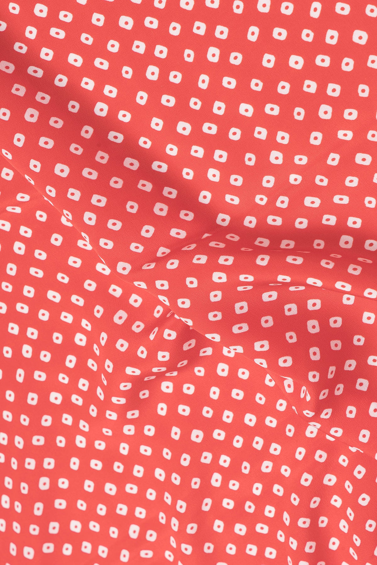 Close up of Red Dual Tone Mysore Crepe Saree with Bandhani Print on the body and Without Border.  displaying folds