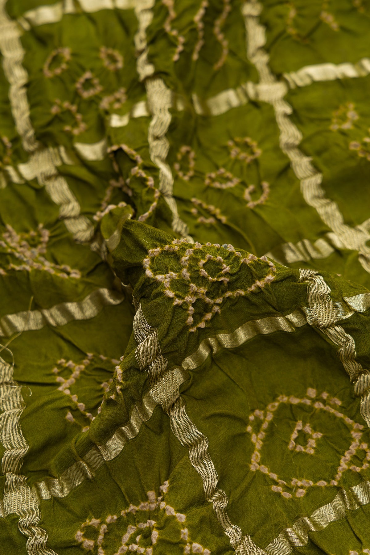 Close up of Mehandi Green Dual Tone Bandhani Silk Saree with Bandhani Print on the body and Without Border.  displaying folds
