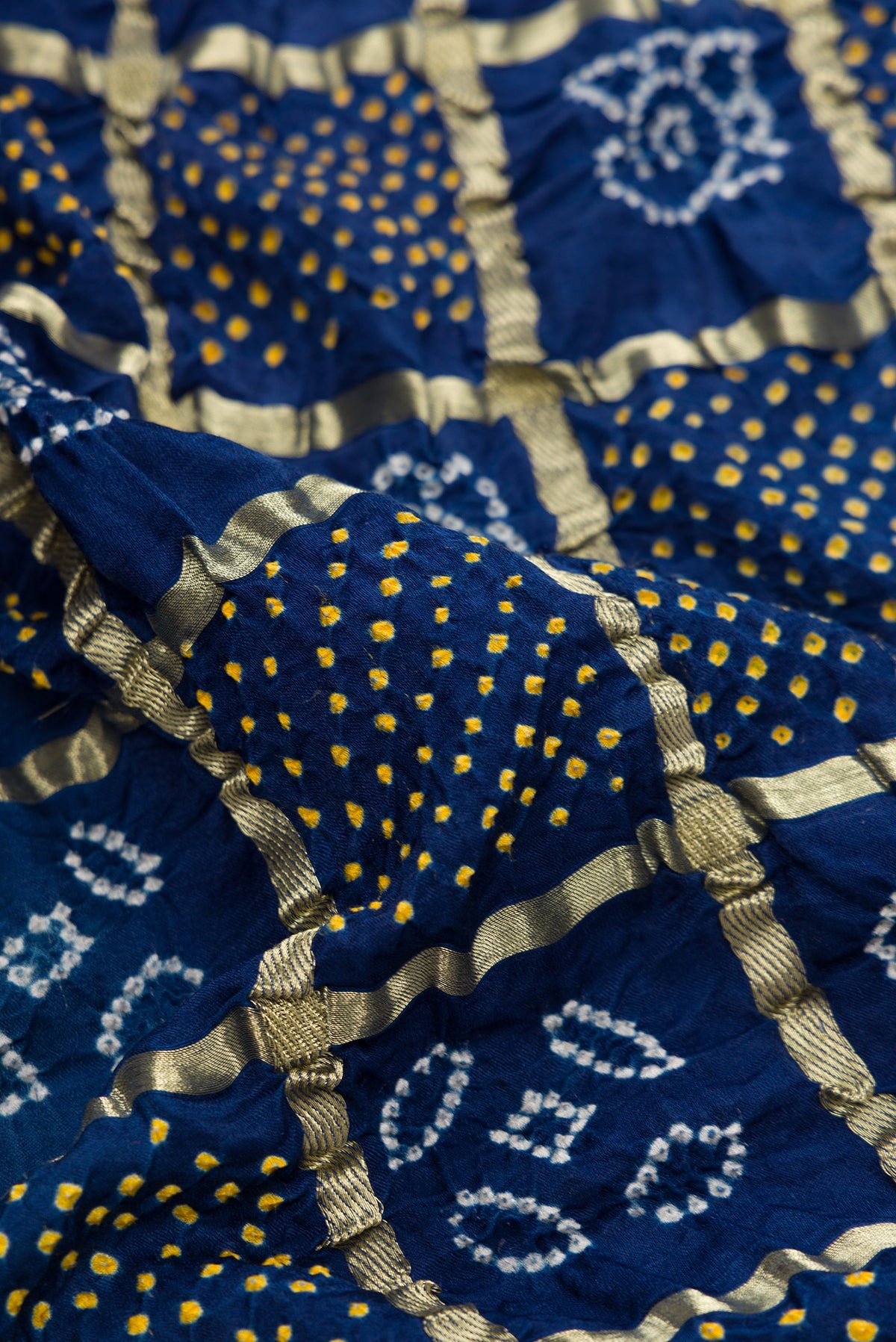 Close up of Navy Blue Dual Tone Bandhani Silk Saree with Bandhani Print on the body and Without Border.  displaying folds