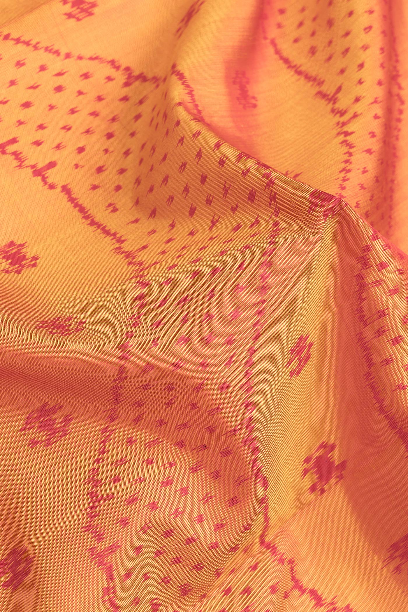 Close up of Mustard Dual Tone Rajkot Patola Silk Saree with Ikat Print on the body and Zari Border.  displaying folds