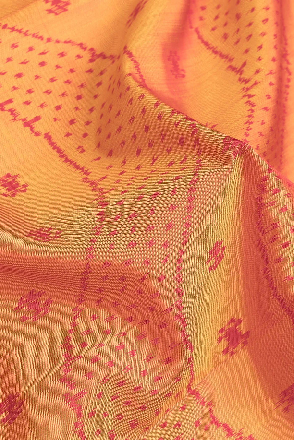 Close up of Mustard Dual Tone Rajkot Patola Silk Saree with Ikat Print on the body and Zari Border.  displaying folds