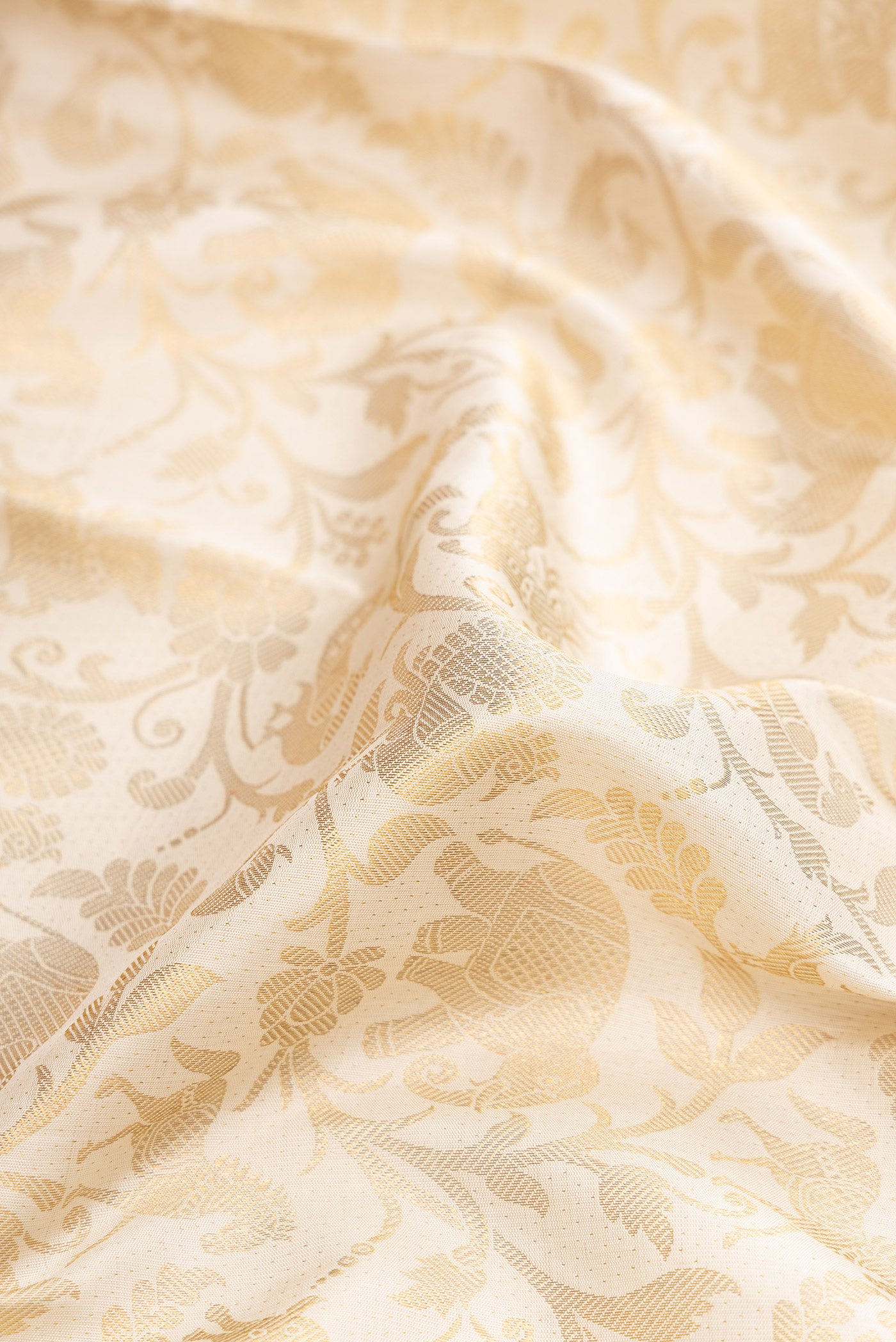 Close up of Off White Dual Tone Kanchipuram Silk Saree with Zari Brocade on the body and Zari Border.  displaying folds