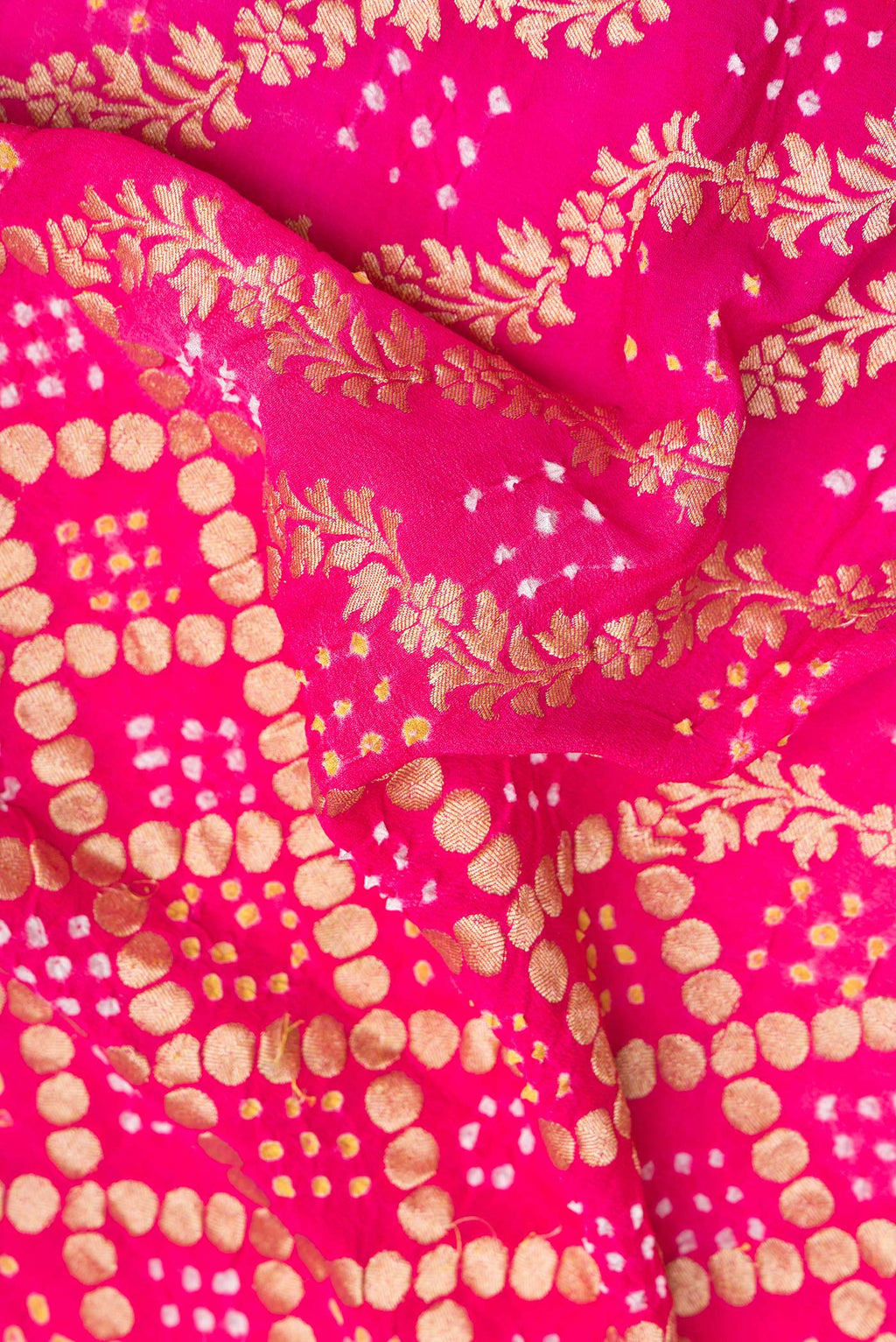 Close up of Pink Bandhani Georgette Saree with Zari Brocade on the body and Zari Border.  displaying folds