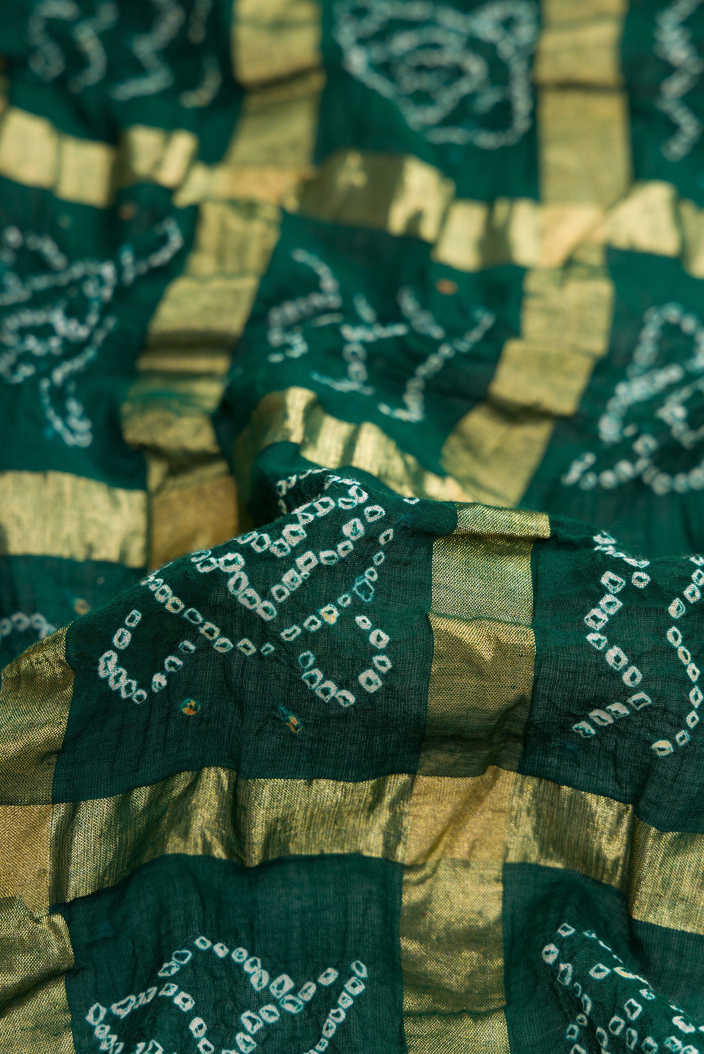 Close up of Bottle Green Dual Tone Bandhani Silk Saree with Bandhani Print on the body and Paithani Border.  displaying folds