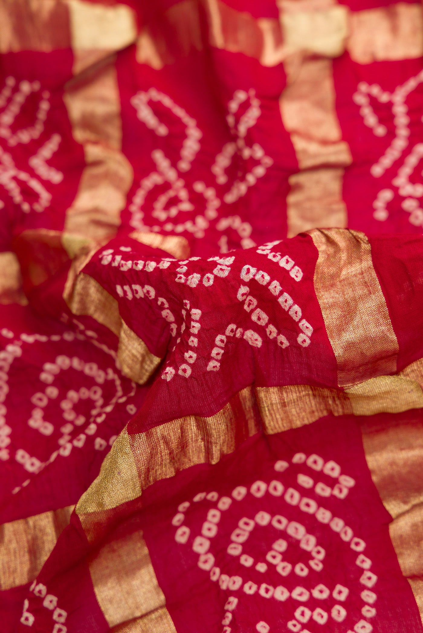 Close up of Maroon Dual Tone Bandhani Georgette Saree with Bandhani Print on the body and Paithani Border.  displaying folds