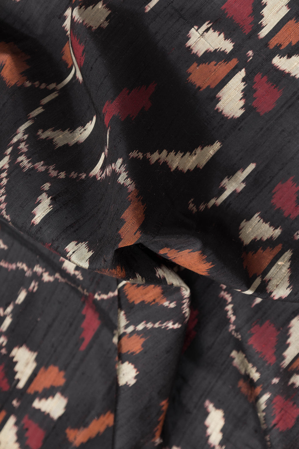 Close up of Black Dual Tone Double Ikat Saree with Ikat Print on the body and Paithani Border.  displaying folds
