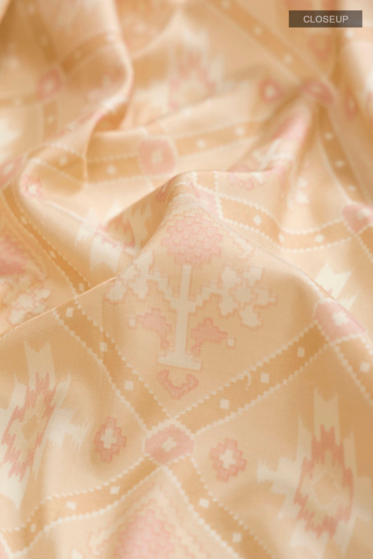 Close up of Beige Printed Silk Saree with Printed design on the body and Zari Border displaying folds