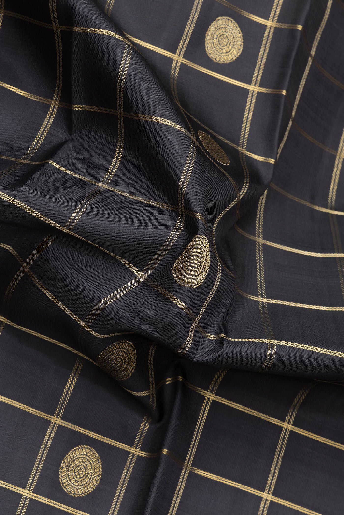 Close up of Black Dual Tone Kanchipuram Silk Saree with Checked design on the body and Zari Border.  displaying folds