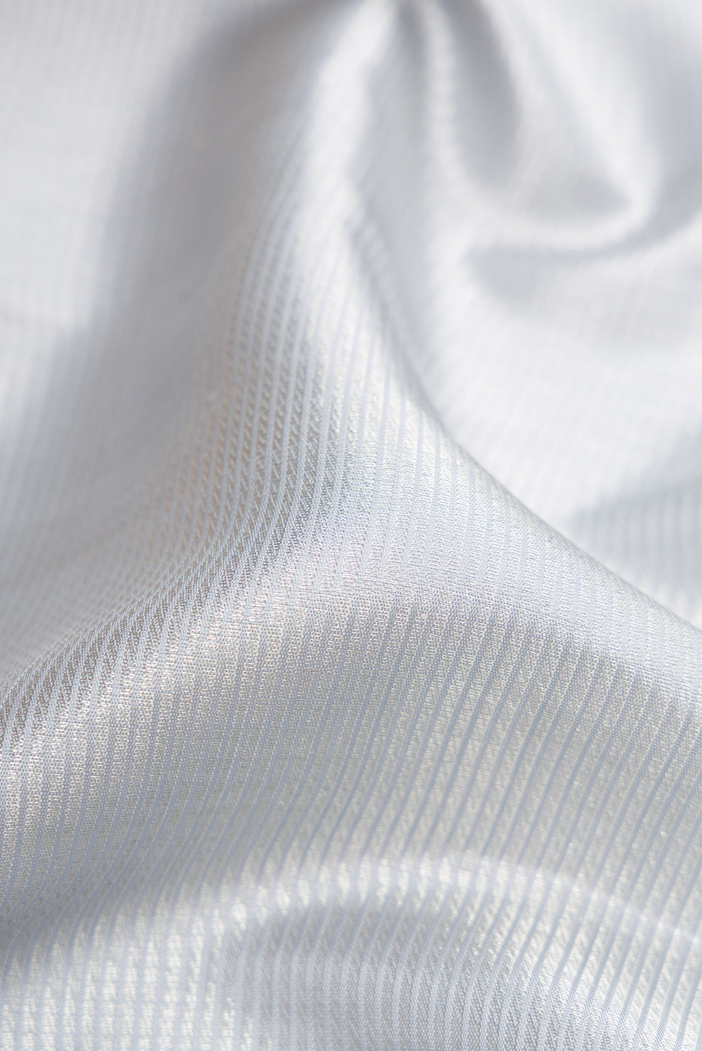 Close up of Grey Dual Tone Kanchipuram Silk Saree with Zari Brocade on the body and Zari Border.  displaying folds
